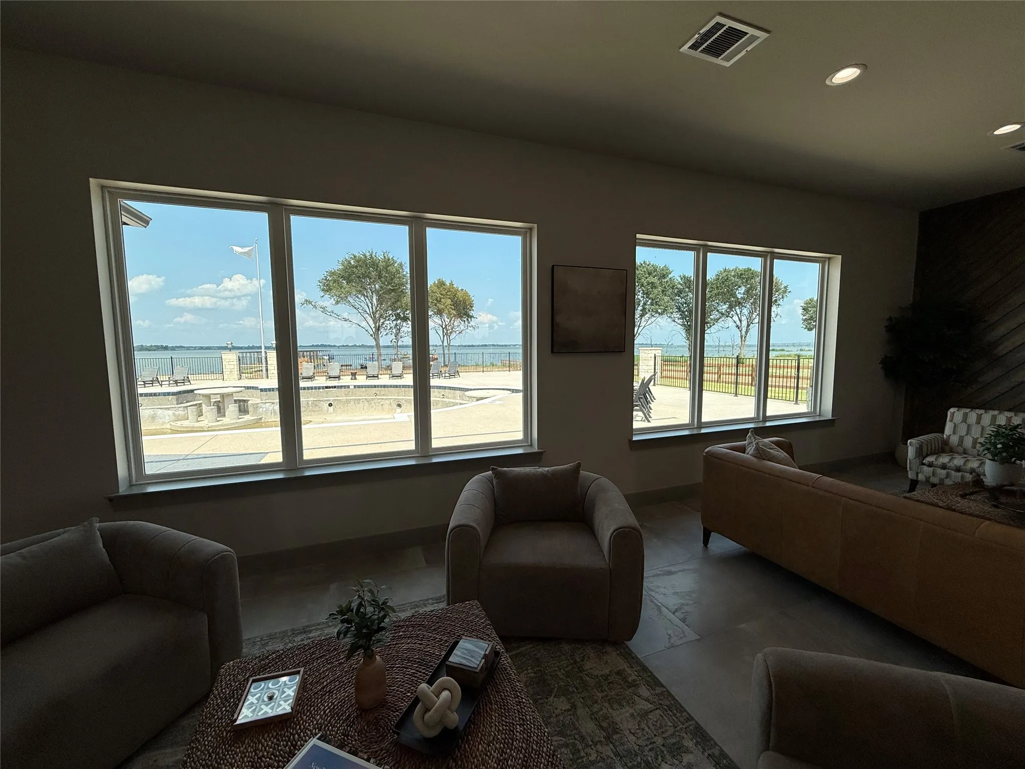 Expansive window wall overlooking an outdoor pool and waterfront