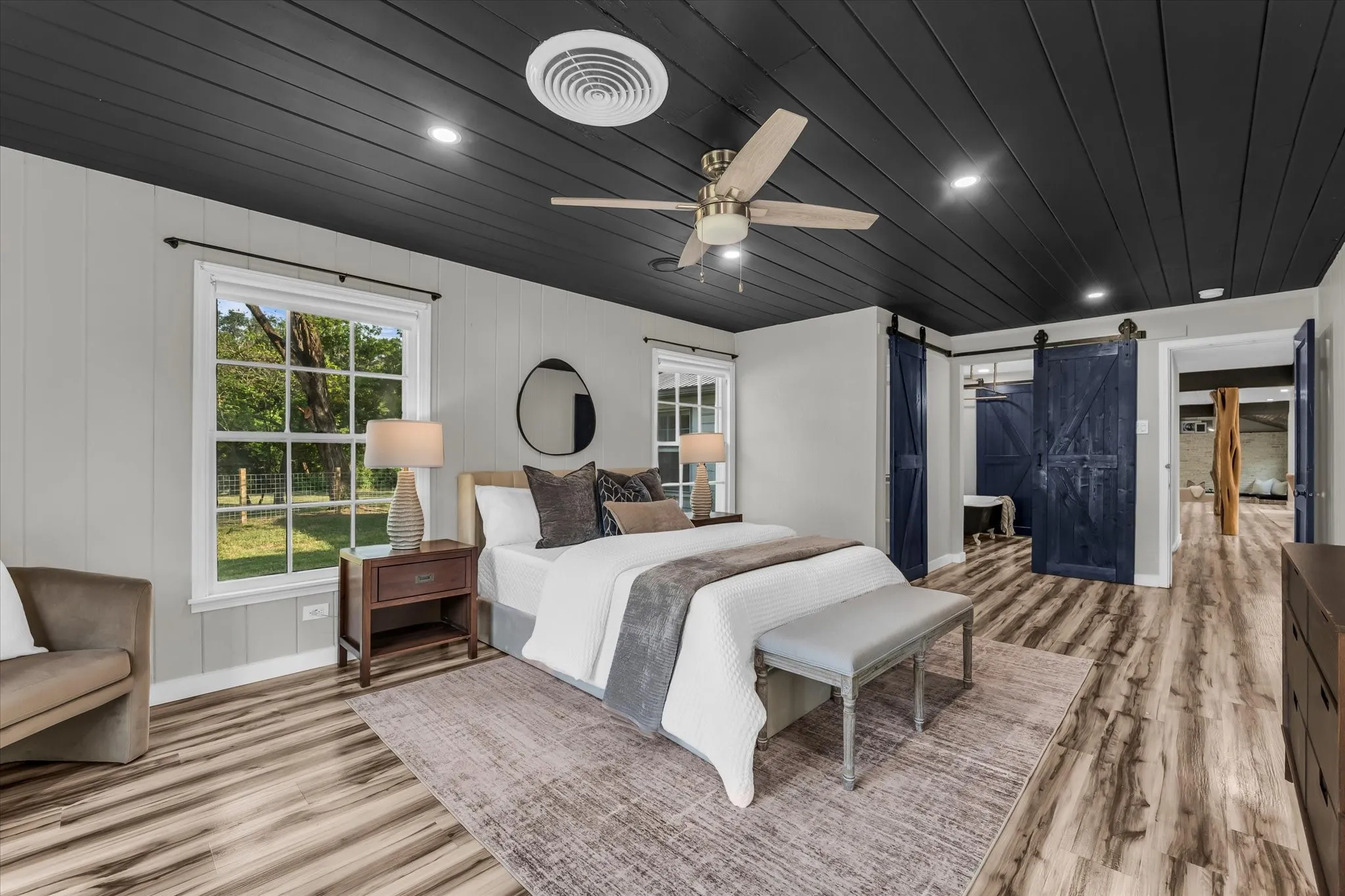 Board-and-batten accent walls, wood-finish flooring, and a dark shiplap ceiling with recessed lighting