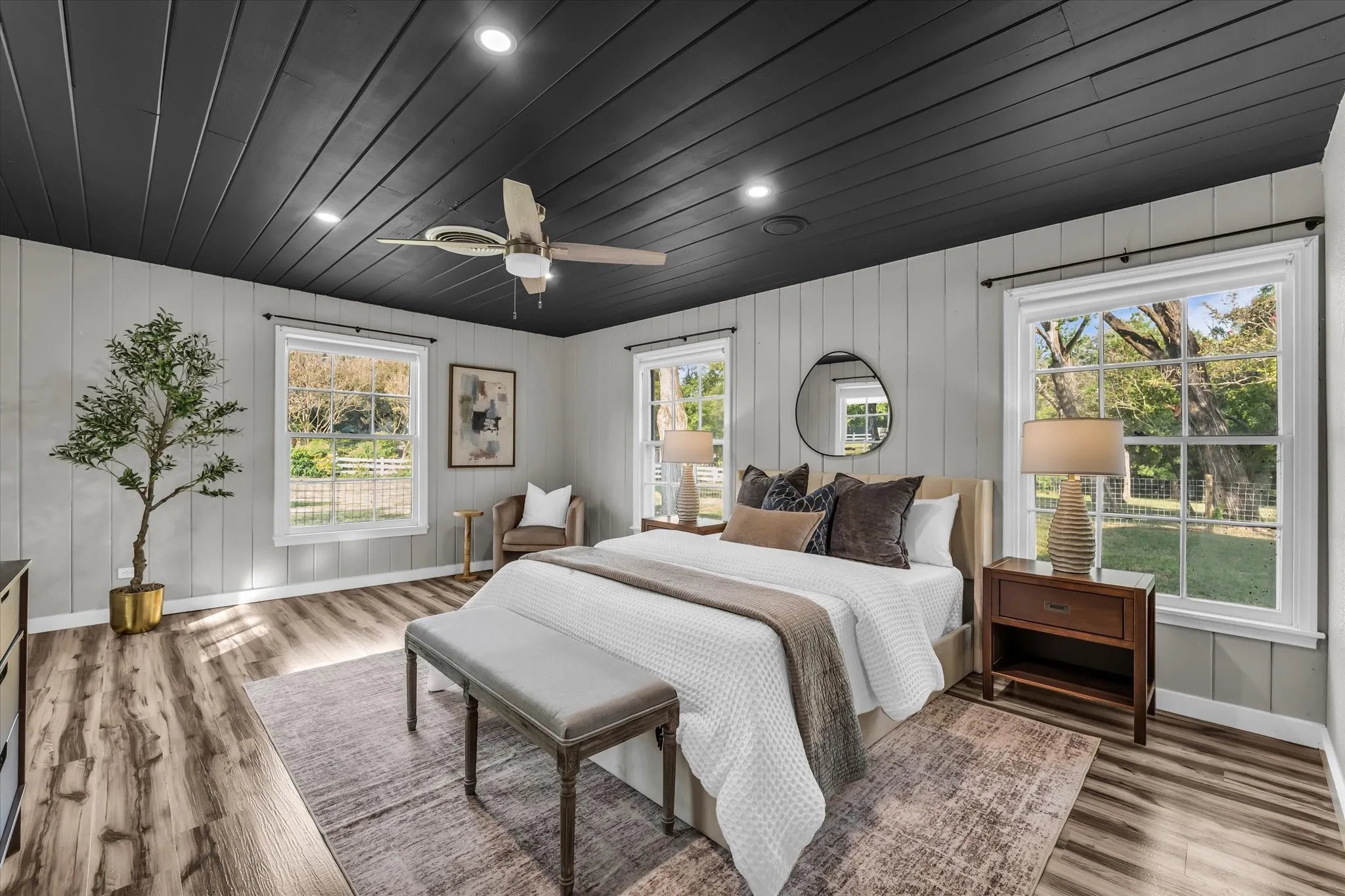 Interior room featuring wood-finish flooring, light grey vertical paneling, and a dark shiplap ceiling