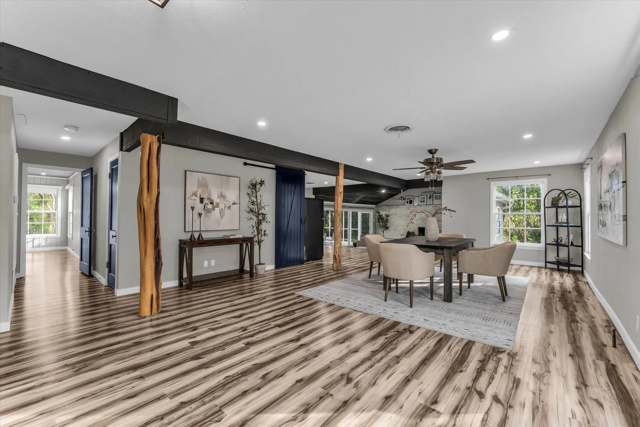 Spacious open-concept living area featuring wood-finish flooring, recessed lighting, and a dark wood ceiling fan