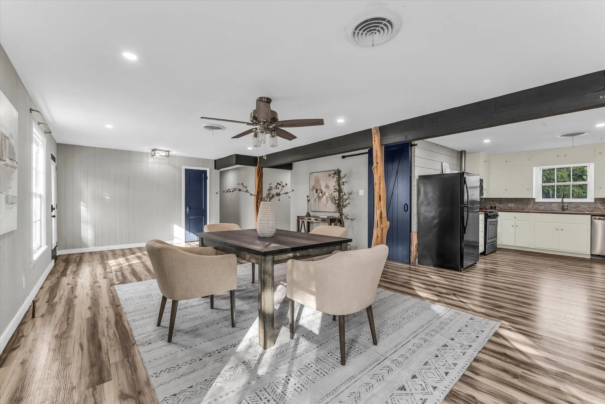 Open-concept dining area featuring wood-finish flooring, recessed lighting, and a ceiling fan