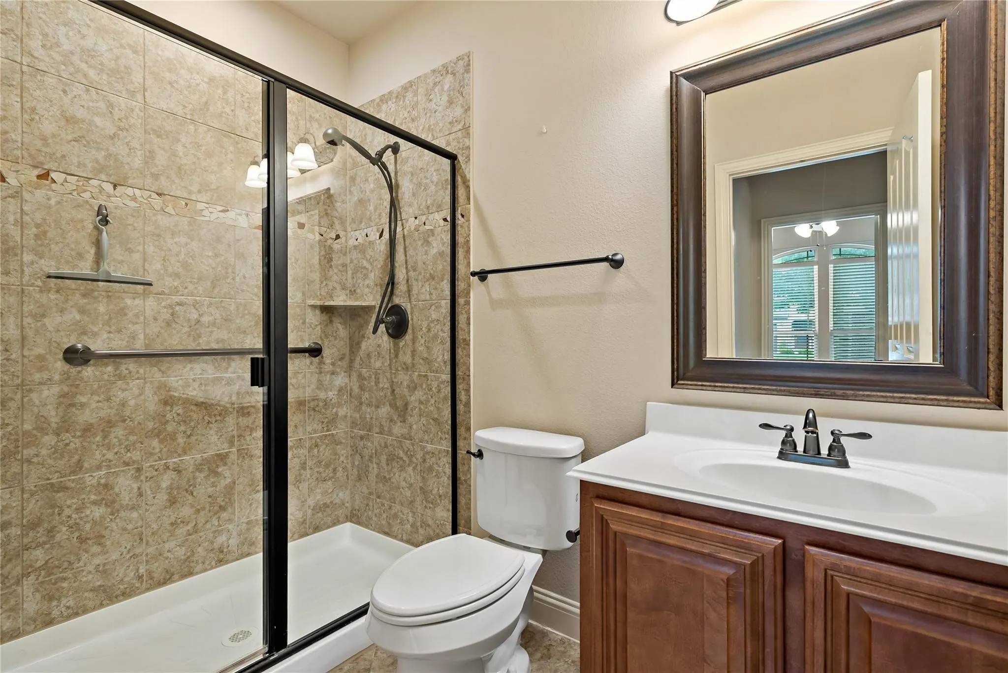 Bathroom featuring a glass-enclosed shower with tiled walls and a built-in shelf