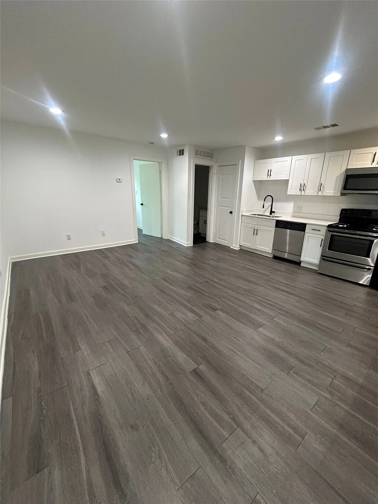 Open-concept living space with wood-finish flooring
