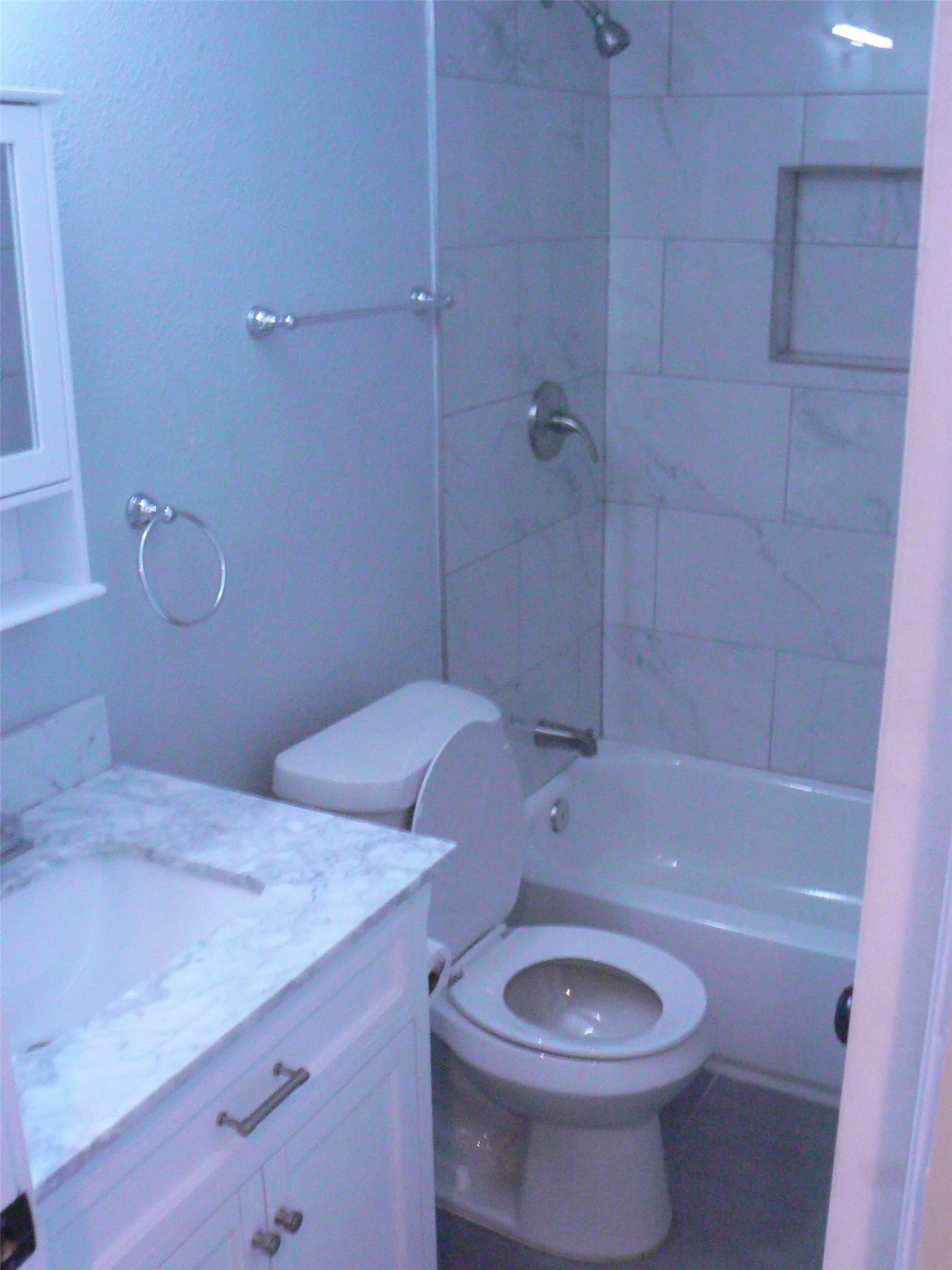Upgrade bathroom with nice vanity, mirror, and shelves behind shower.