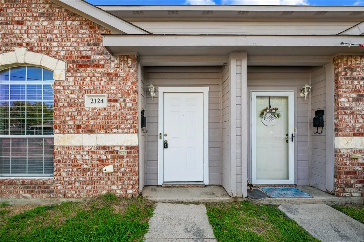 Brick and siding exterior featuring an arched window with stone trim