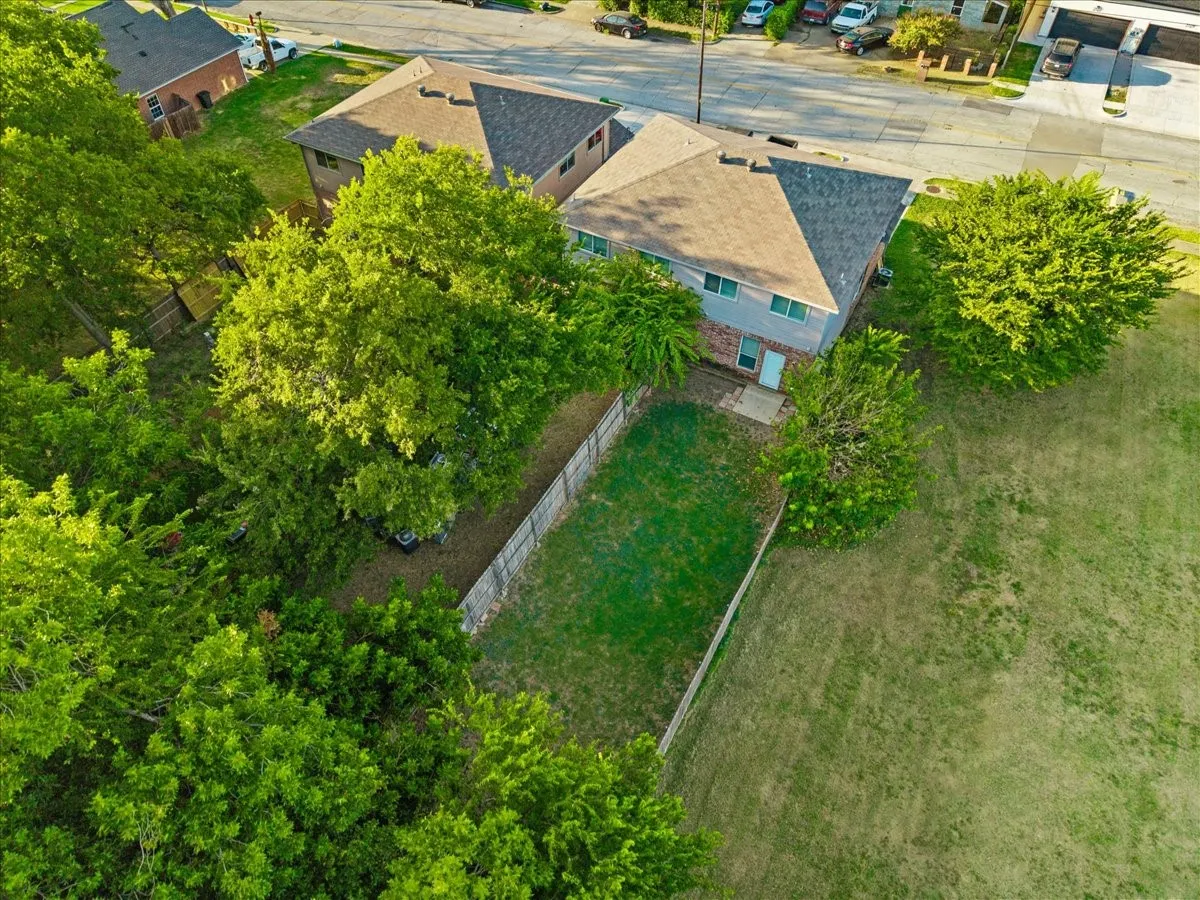 Two-story residence with a gray exterior, a shingled roof, and a private fenced yard