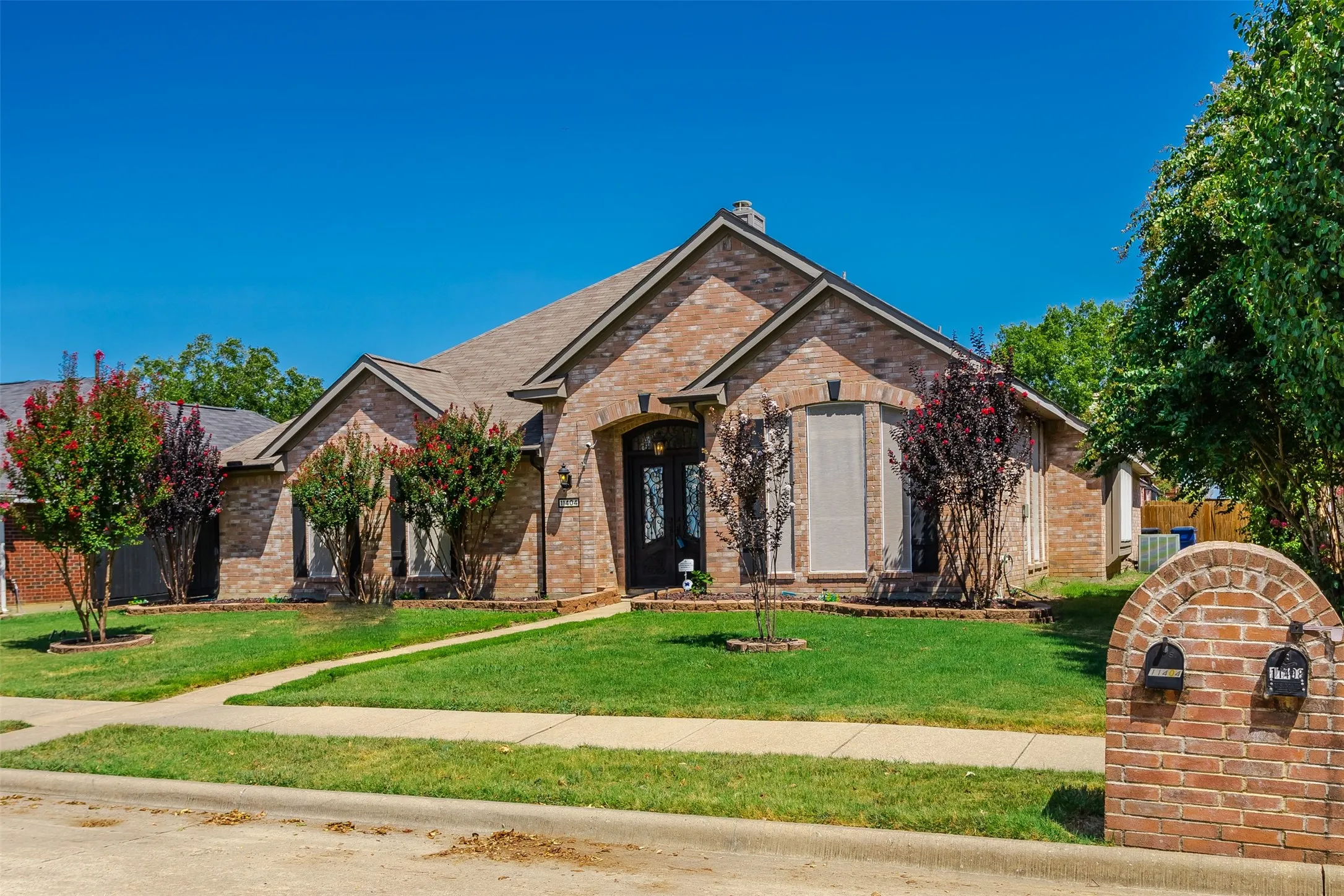 Brick exterior with arched entry, bay window, and gabled roofline