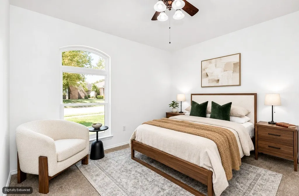 Arched window providing ample natural light, ceiling fan with integrated lighting, and neutral wall tones