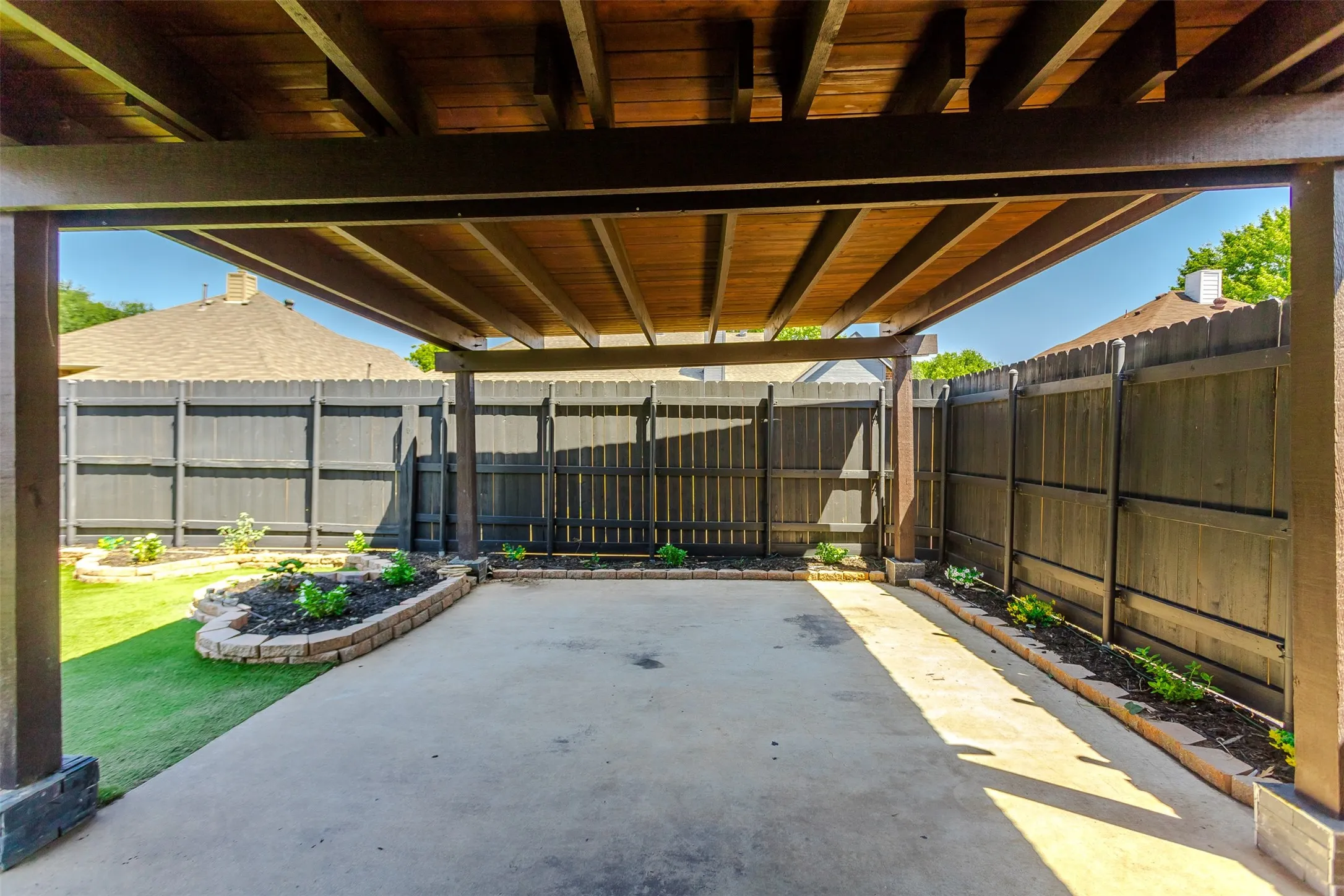 Covered patio featuring wood ceiling and structural beams