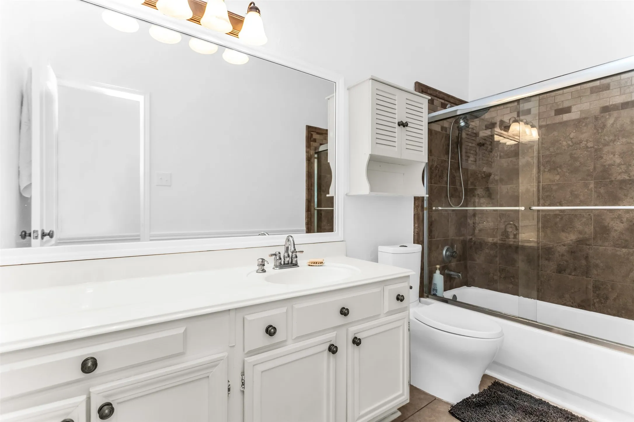 White vanity with ample counter space, integrated sink, and cabinet storage
