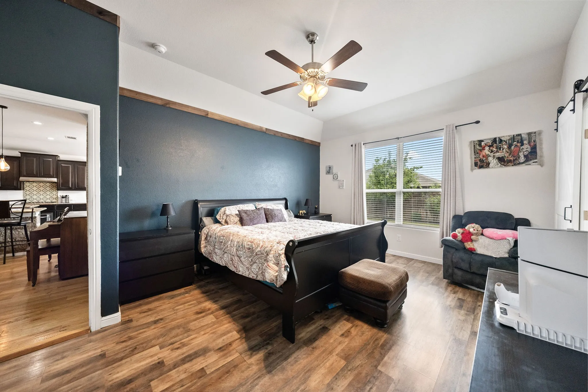 Bedroom featuring wood-finish flooring, a vaulted ceiling, and a ceiling fan with integrated lighting