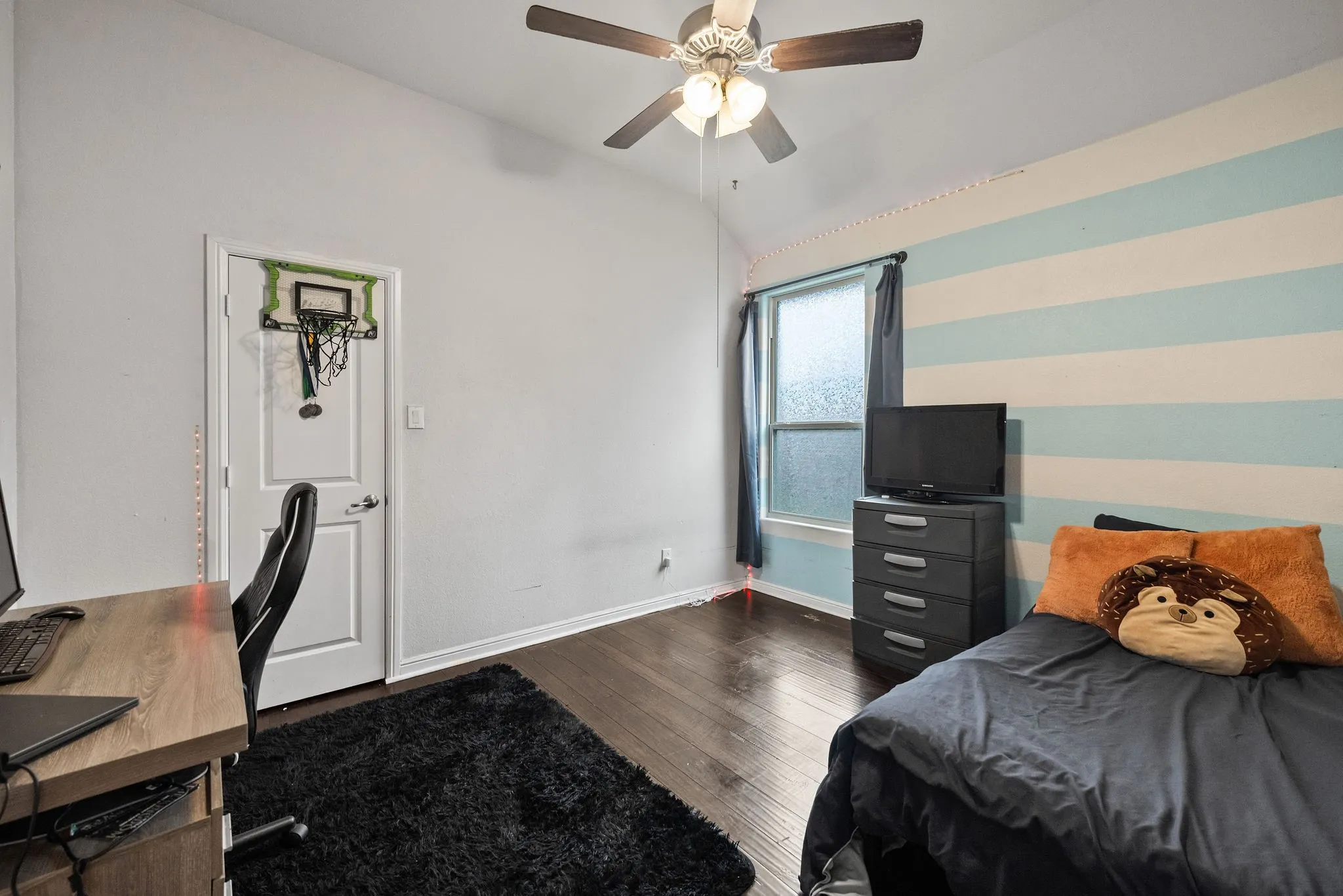 Interior room with dark wood-finish flooring, a vaulted ceiling, and a ceiling fan