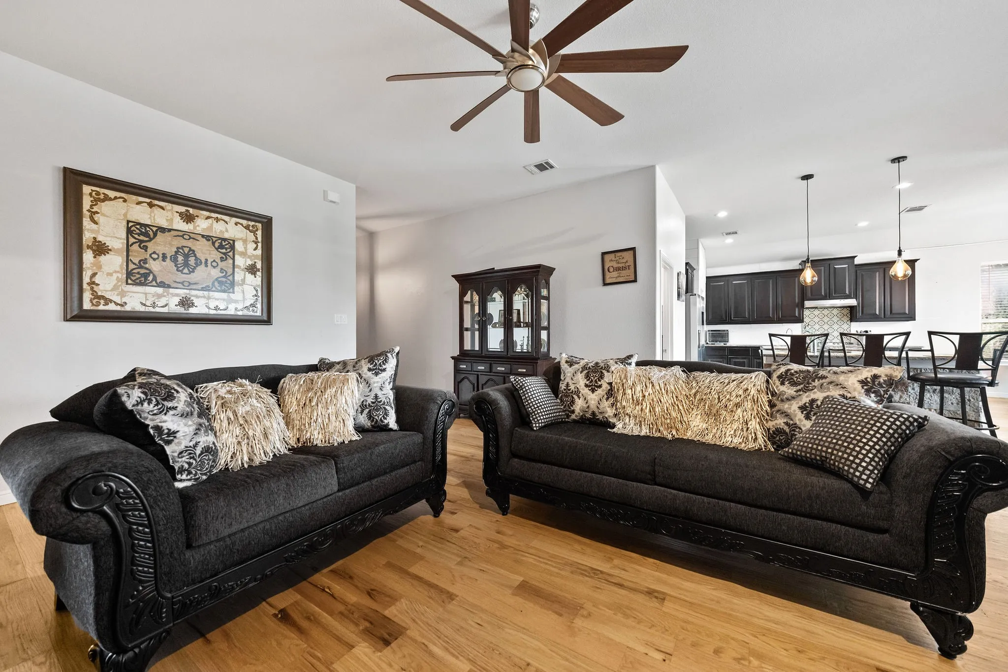 Spacious living area featuring wood-finish flooring, a ceiling fan, and recessed lighting
