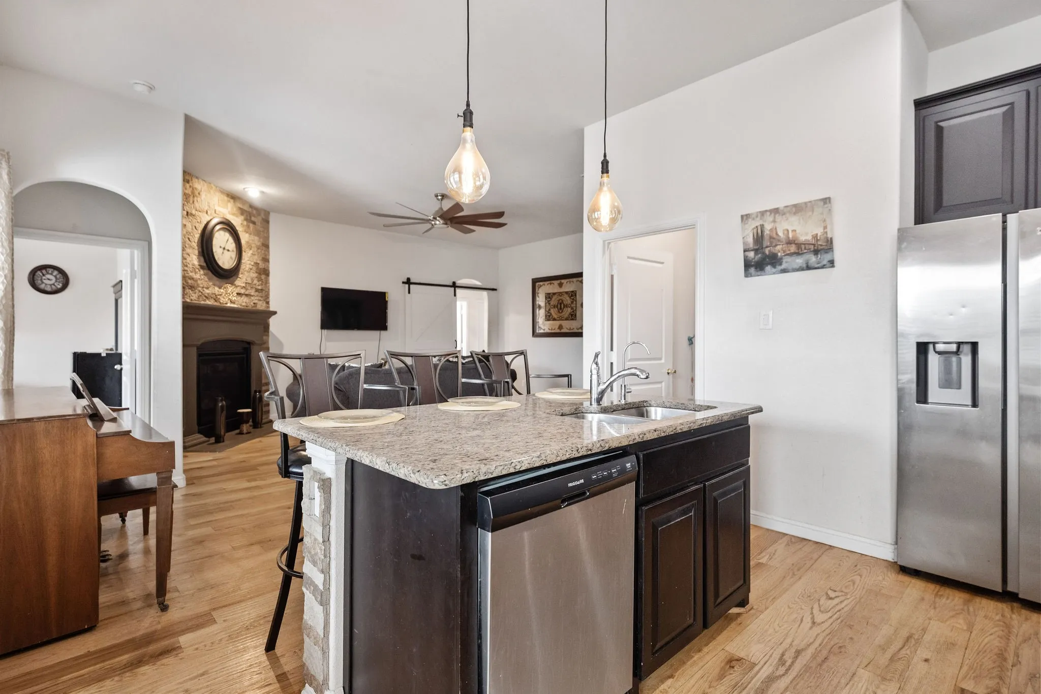 Kitchen island with granite countertop, integrated sink, and stainless-steel dishwasher