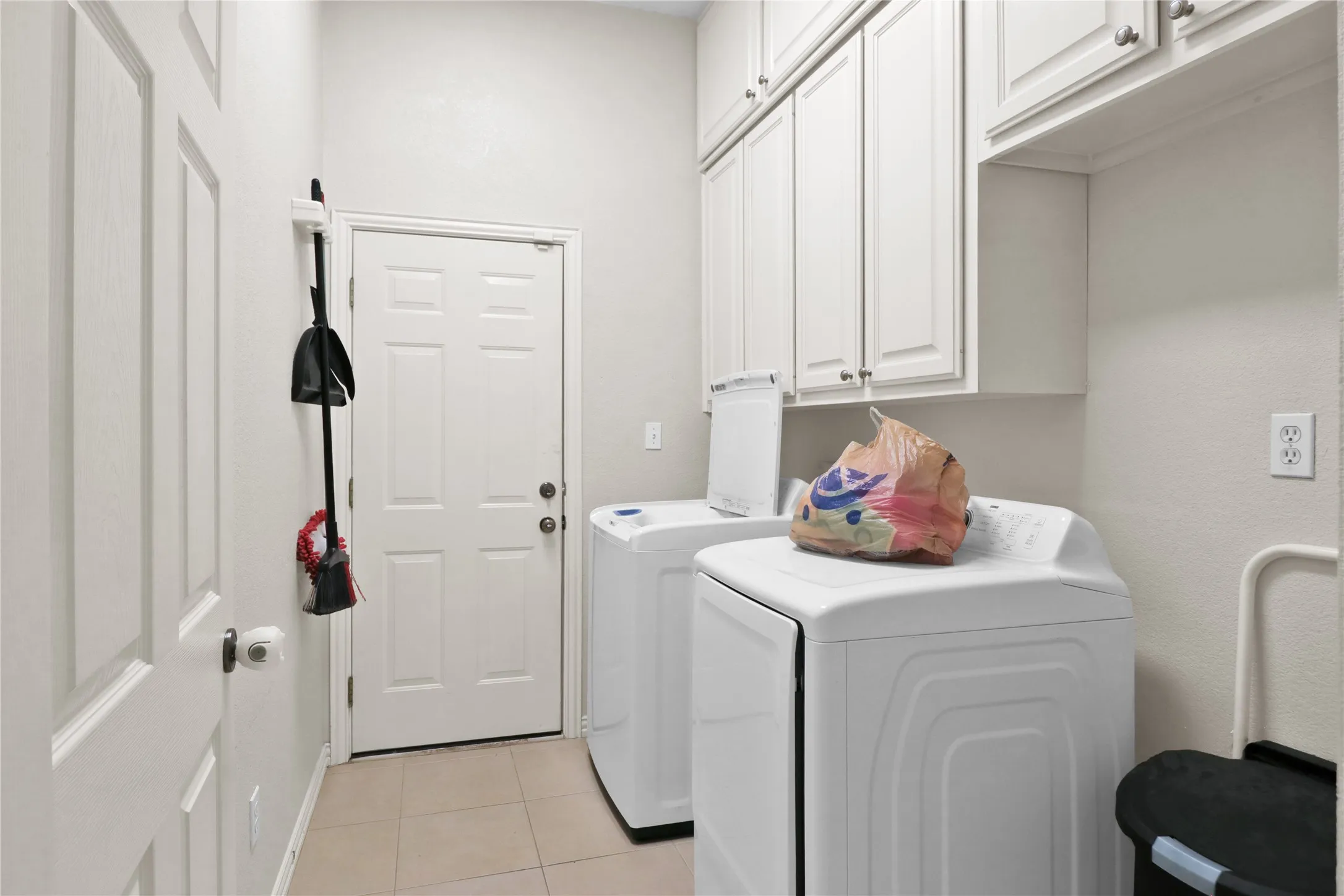 Laundry room with built in cabinets and room for a freezer.
