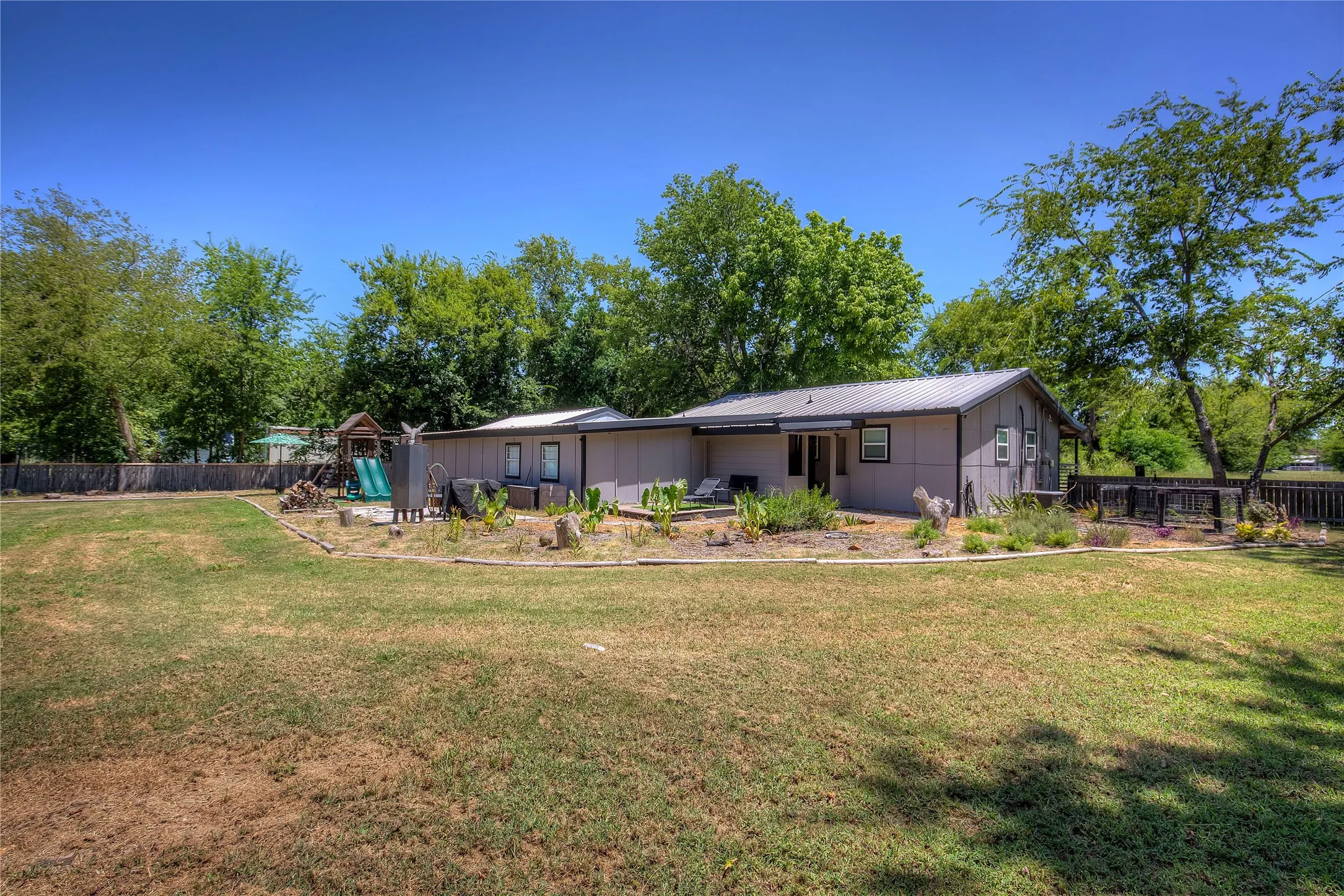 Back of property with board and batten siding and a playground