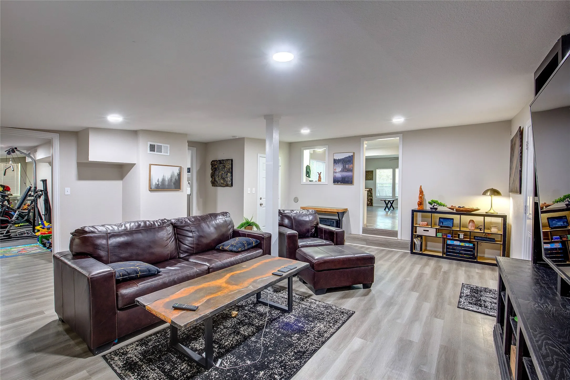 Living room with light wood finished floors and recessed lighting
