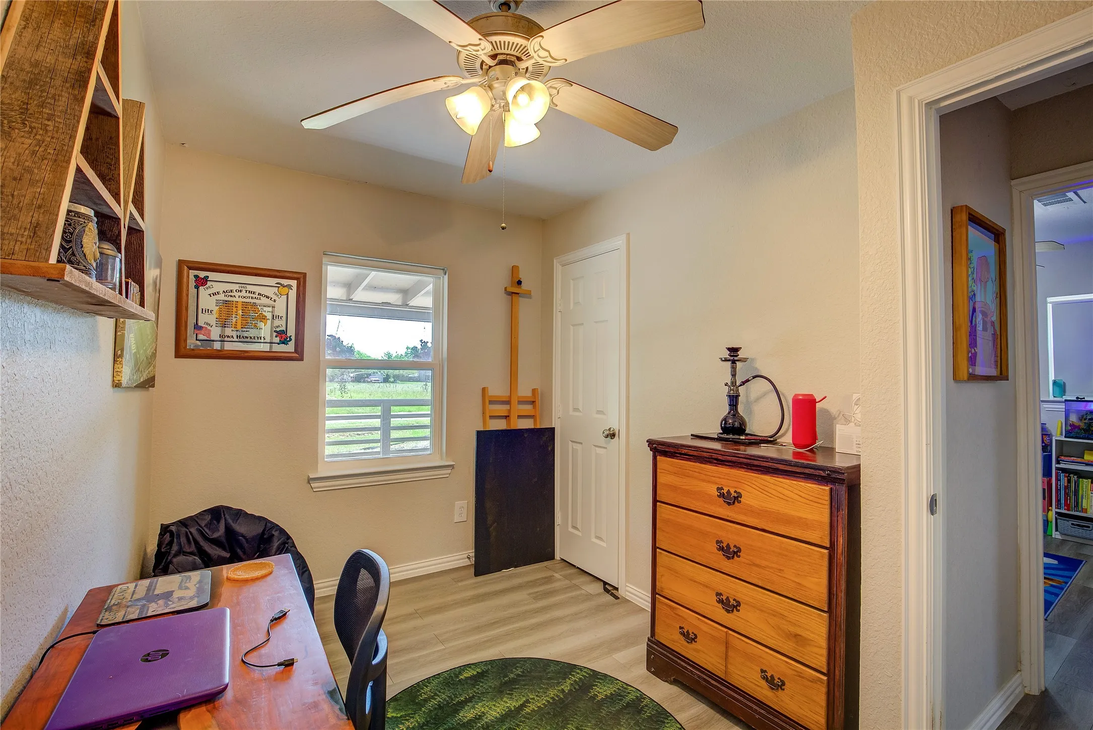 Office with light wood-style flooring and a ceiling fan