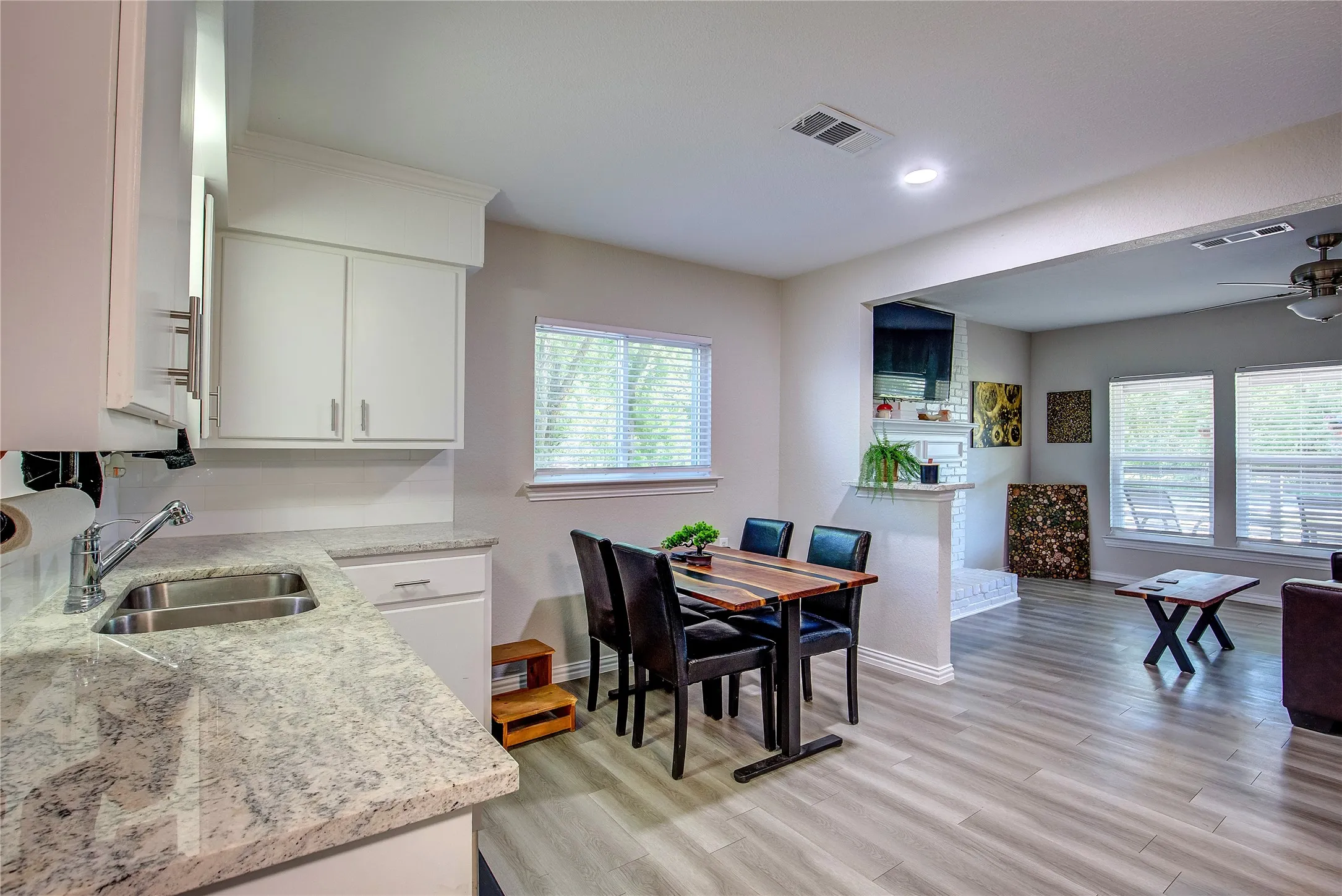Dining space with ceiling fan, light wood finished floors, a fireplace, and recessed lighting