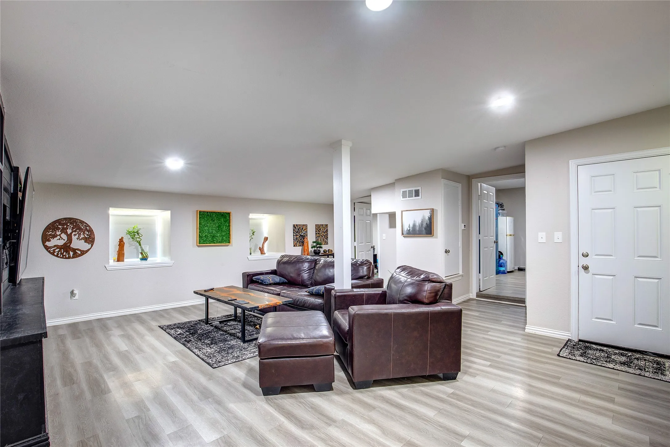 Living area with light wood-style flooring and recessed lighting