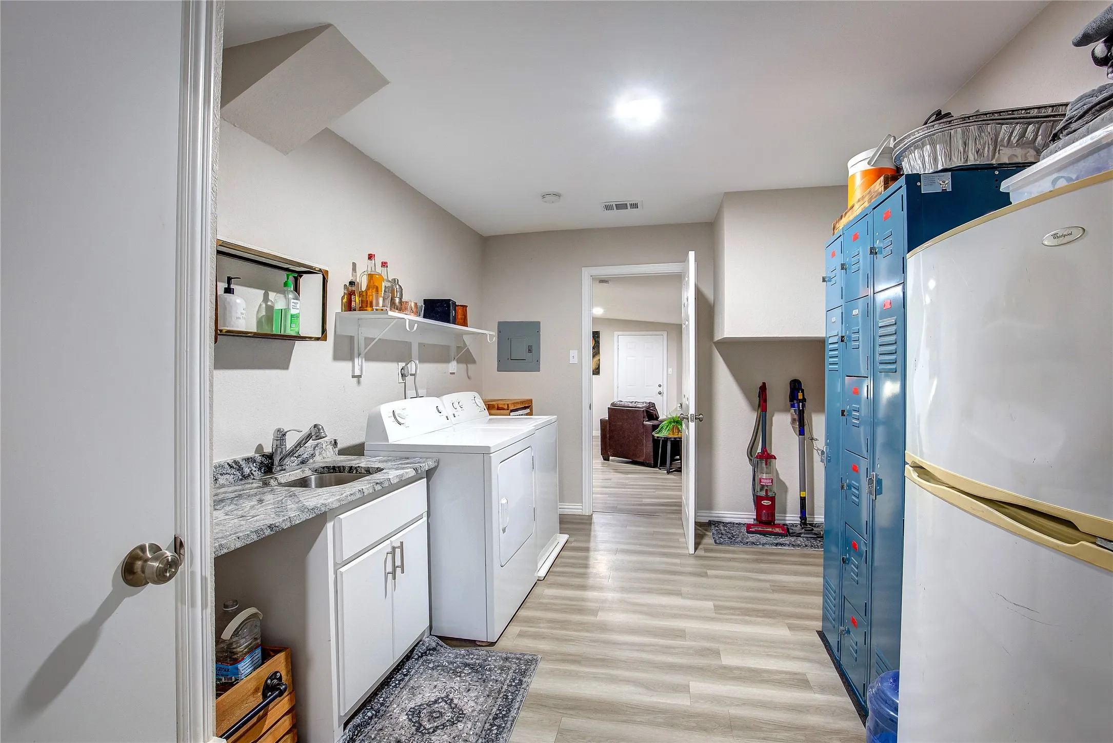 Laundry room with light wood-style floors, washer and dryer, and electric panel
