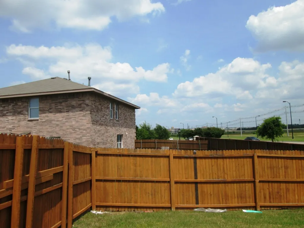 Wood privacy fencing enclosing a green lawn