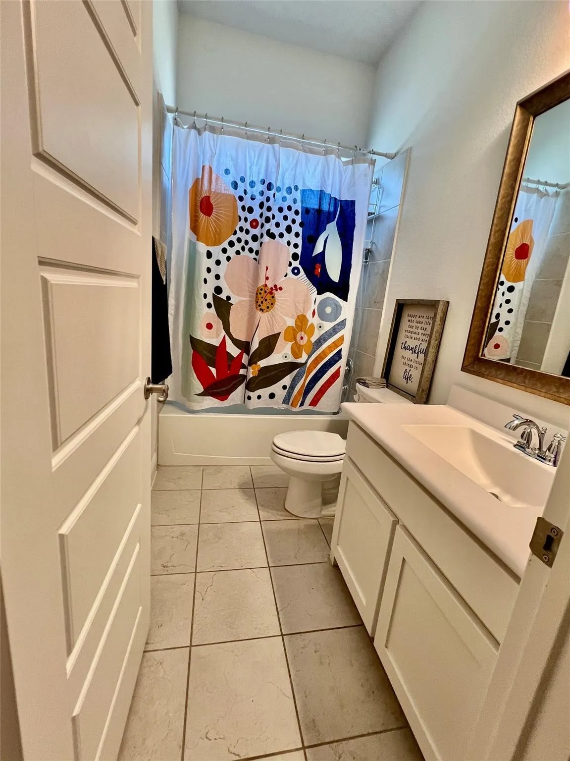 Bathroom featuring a single vanity with integrated sink, white cabinetry, and a full bathtub with shower