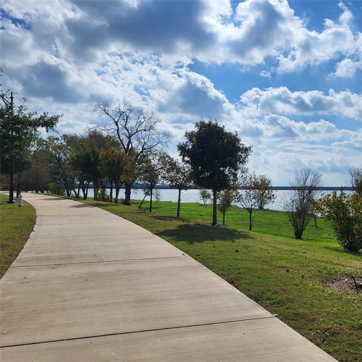Paved concrete pathway bordered by a manicured lawn