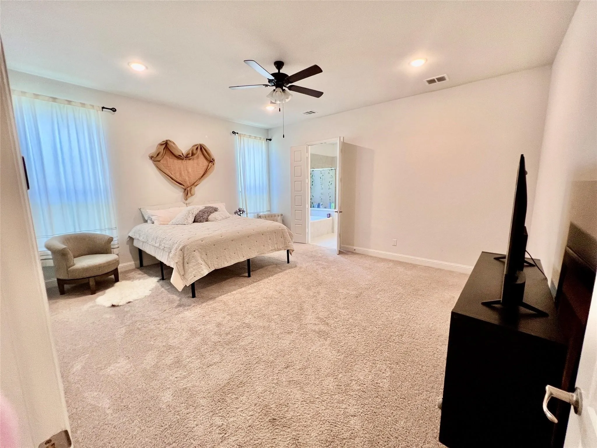 Spacious room featuring neutral carpet flooring, recessed lighting, and a ceiling fan