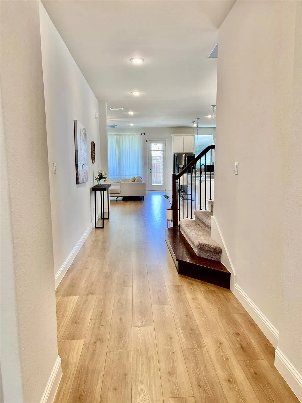 Hallway entry with wood-finish flooring, recessed lighting, and white baseboards