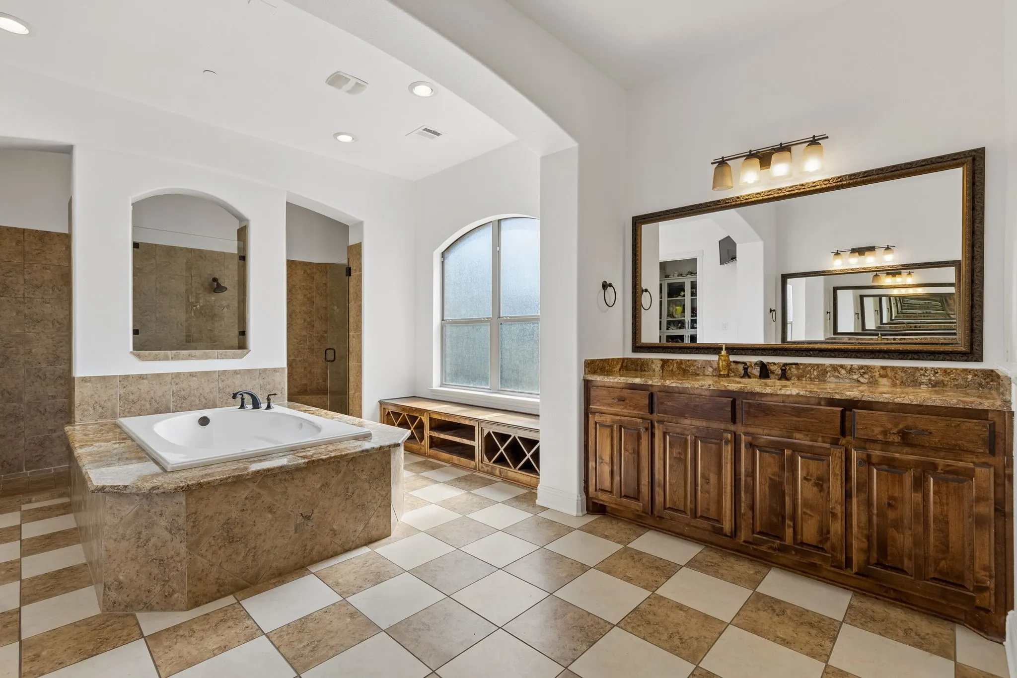 Primary ensuite offers his and her closets, frameless dual shower doors and massive soaking tub...no shortage of storage either!