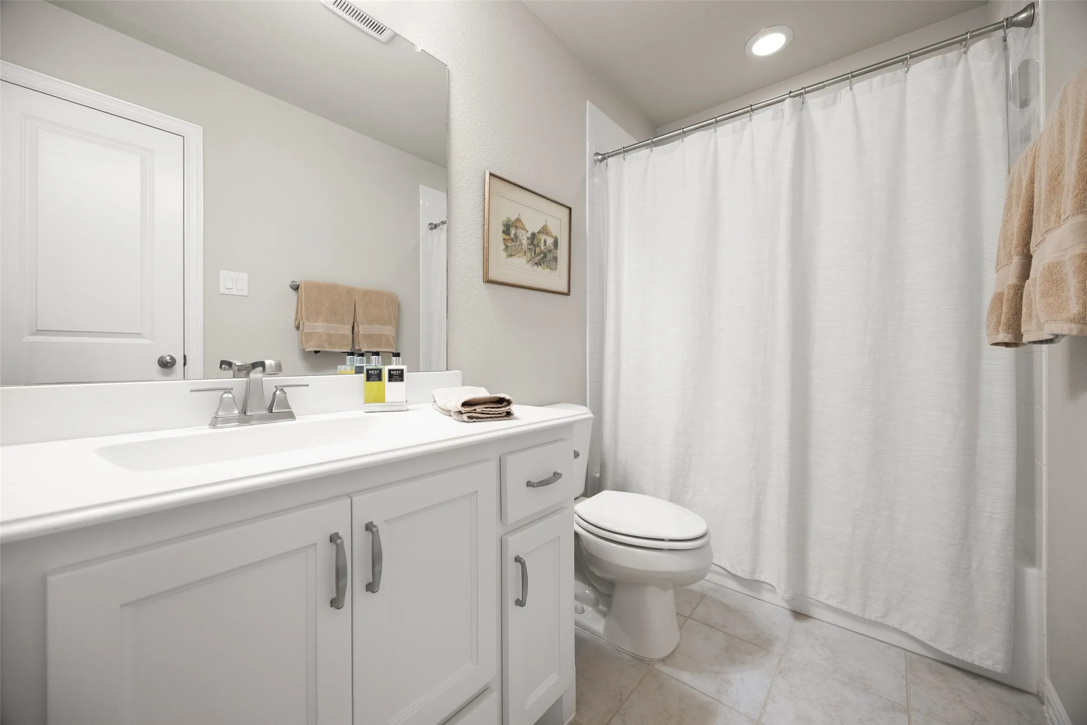 Bathroom featuring a white vanity with integrated sink, chrome faucet, and storage cabinetry
