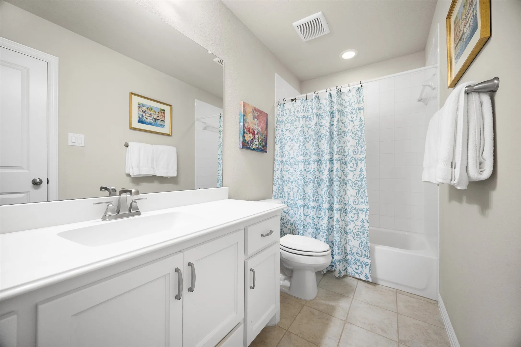 Bathroom featuring a white vanity with integrated sink, coordinating countertop, and chrome faucet
