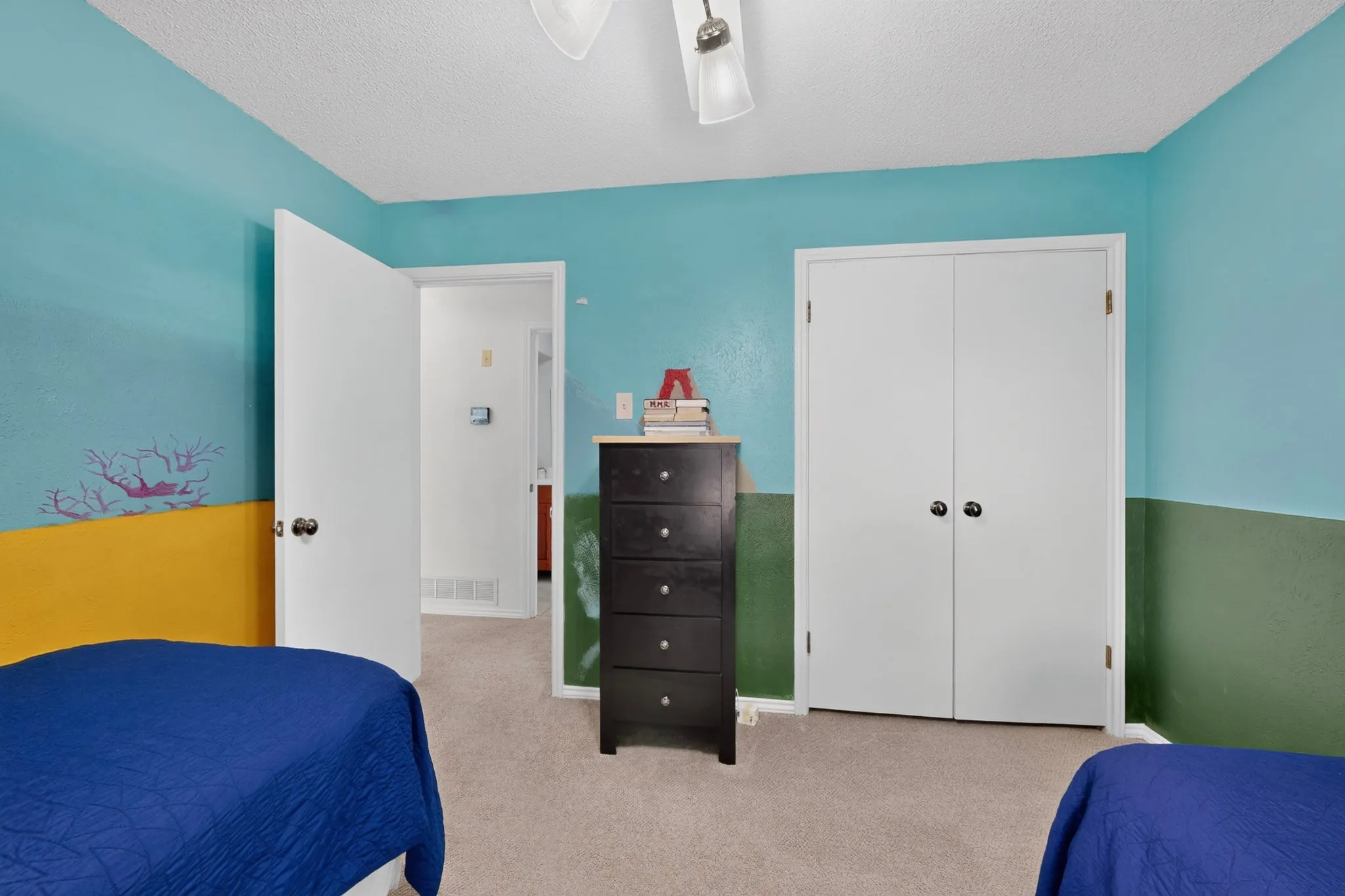 Carpeted room featuring a ceiling fan with integrated lighting, a double-door closet, and a white interior door