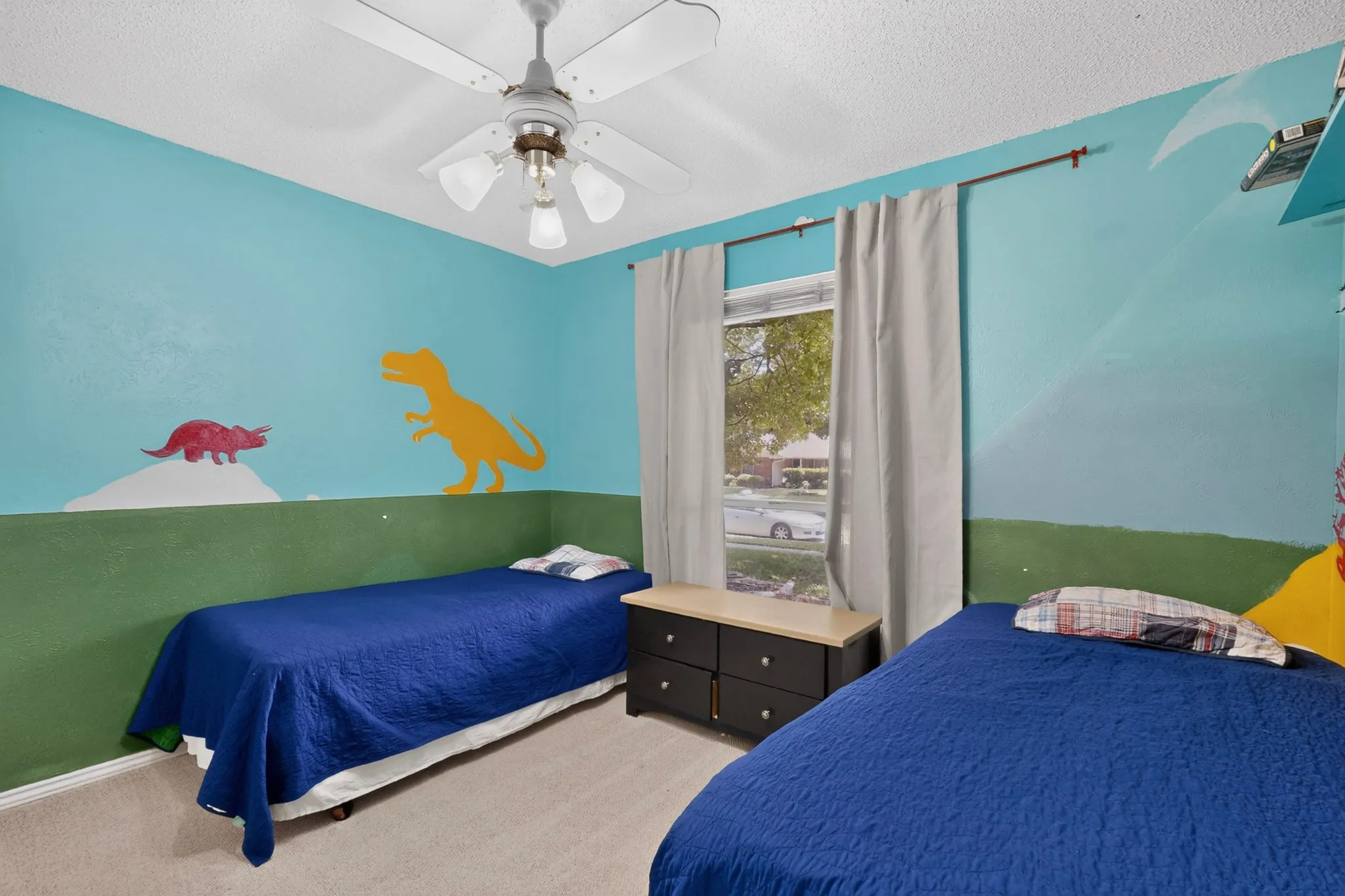 Room featuring a ceiling fan with integrated lighting, a window with natural light, and neutral carpeting
