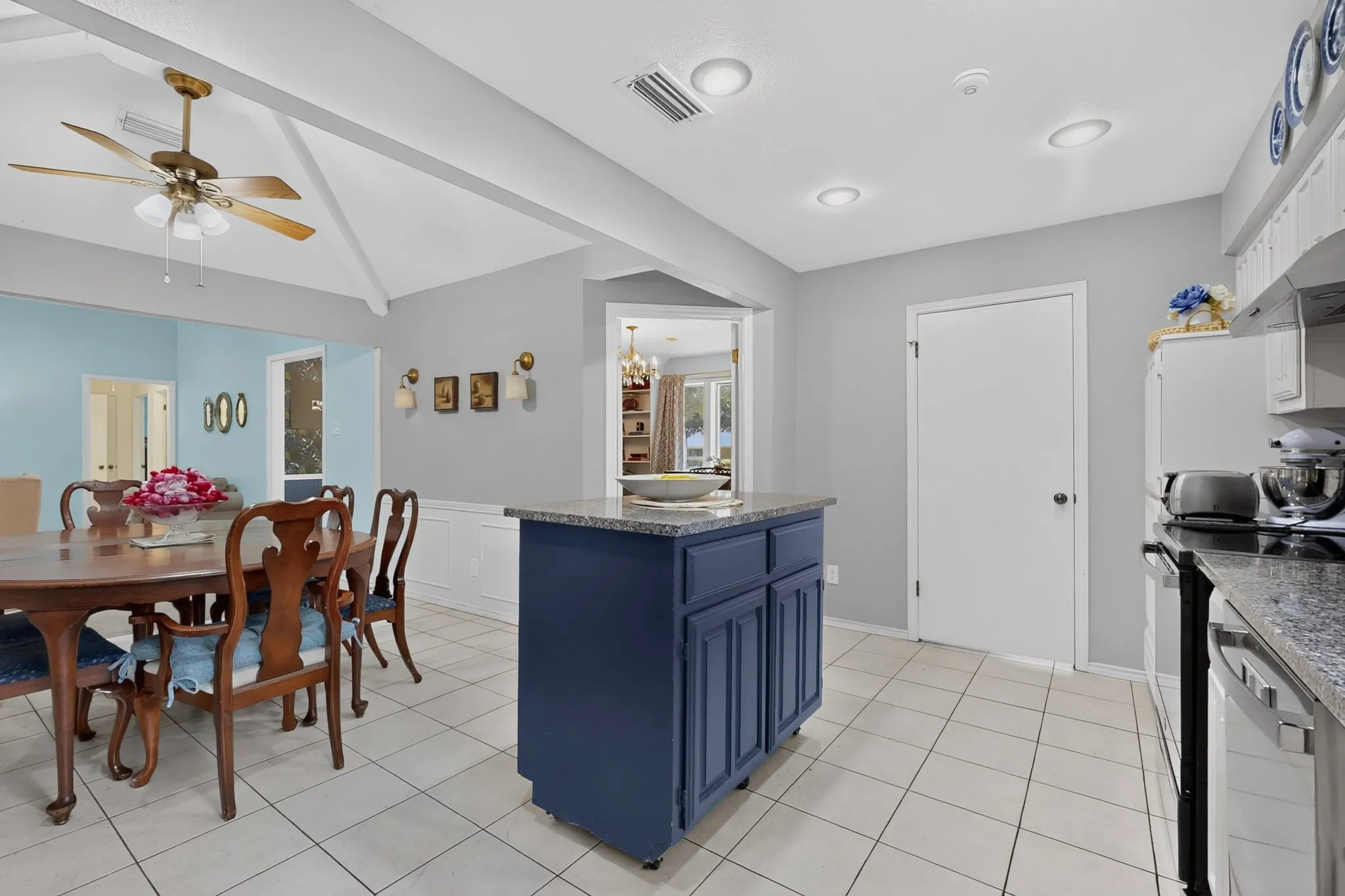Kitchen featuring a blue island with a granite countertop, tile flooring, recessed lighting, and stainless steel appliances