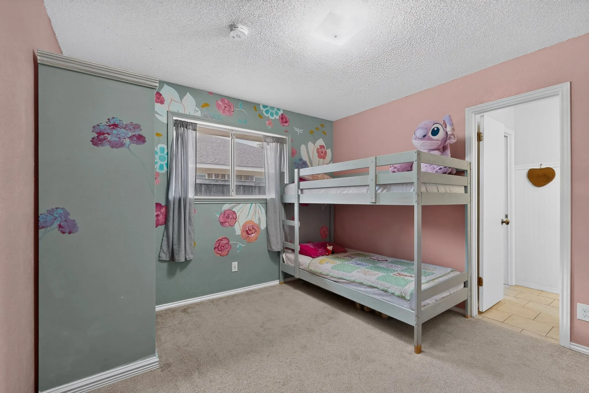 Bedroom with light-colored carpeting and a flush-mount ceiling light