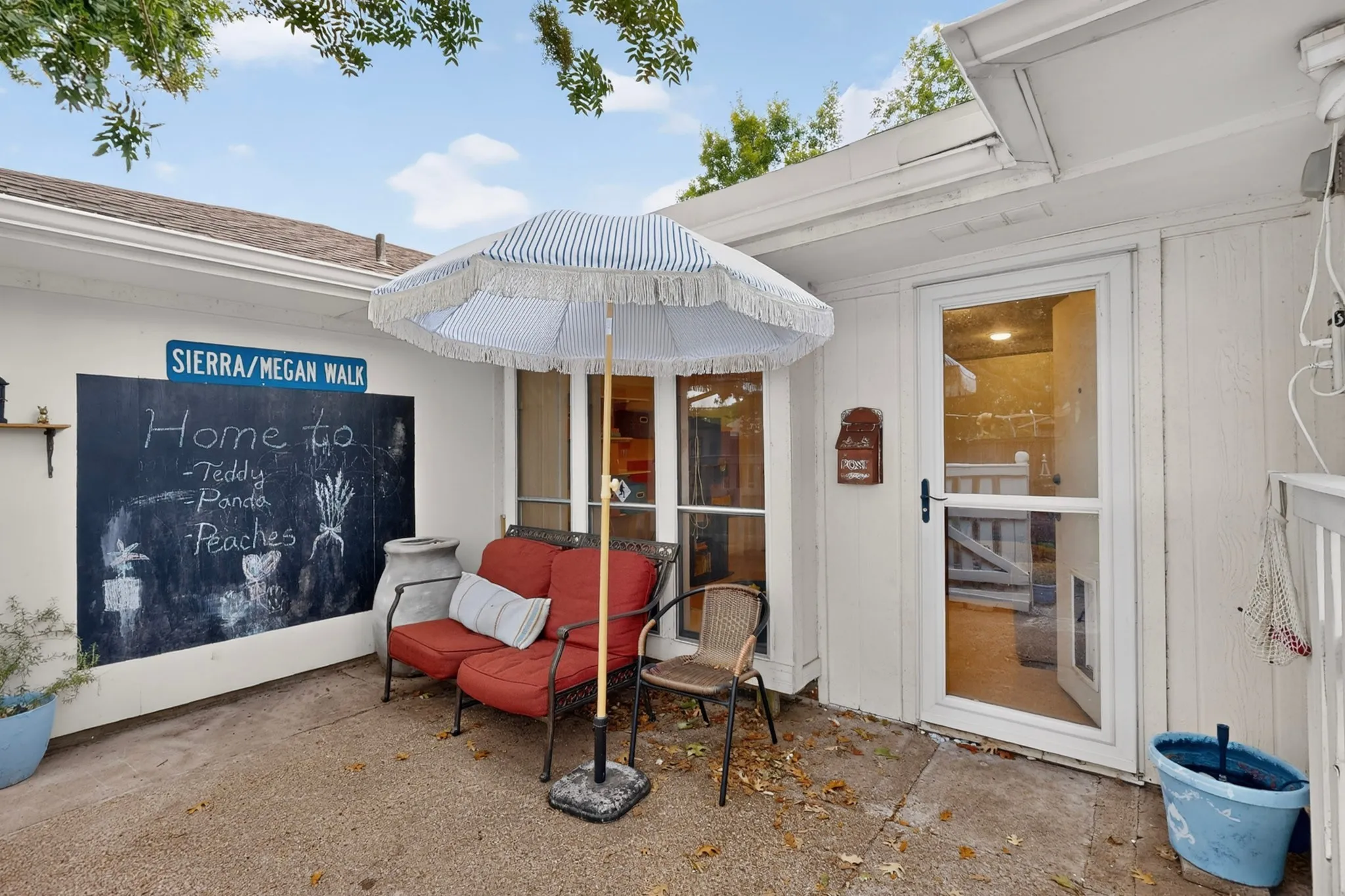 Private patio area featuring a concrete surface, a built-in chalkboard wall, and a glass-paneled exterior door