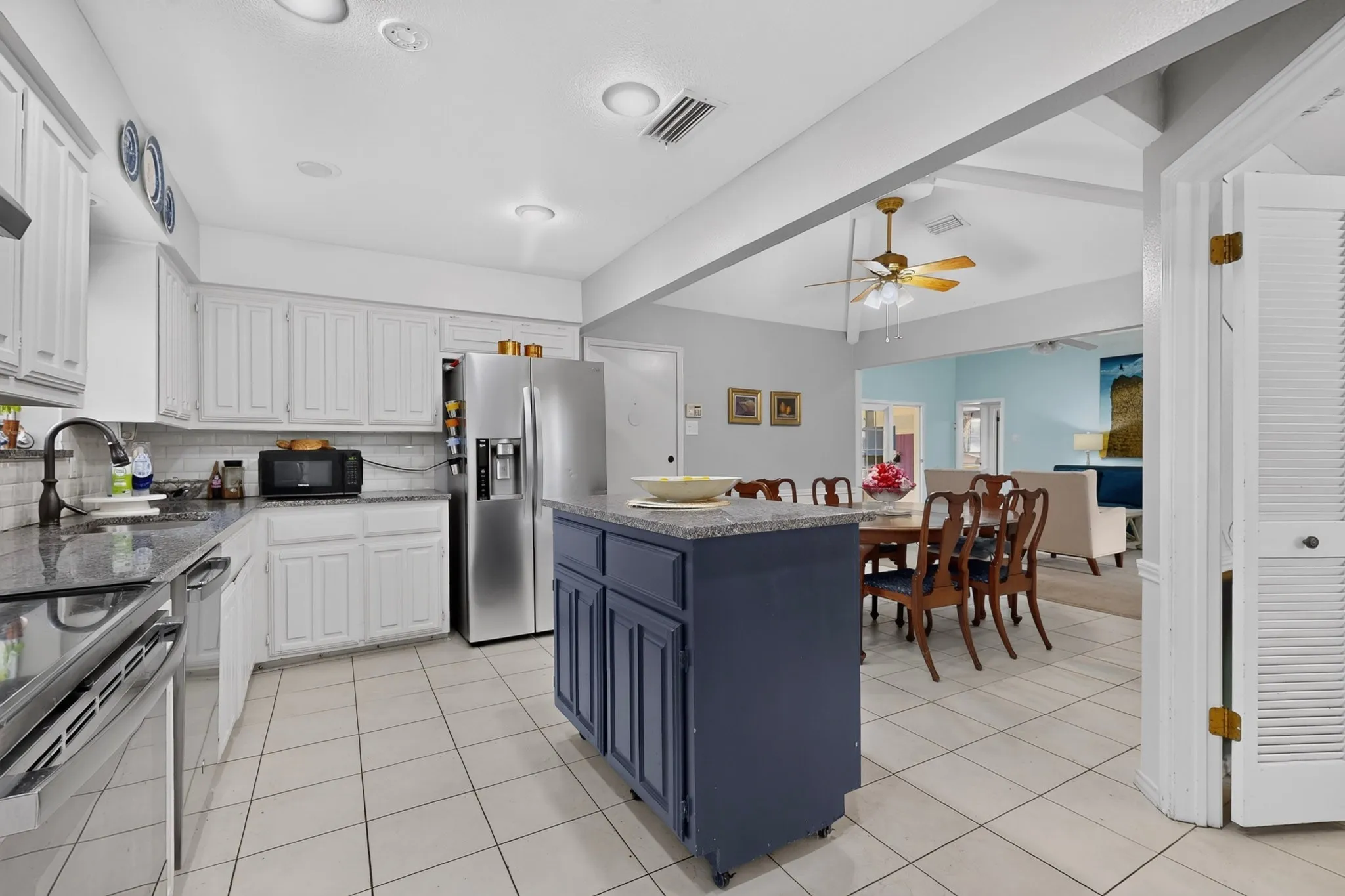 Kitchen featuring white cabinetry, dark granite countertops, and tile flooring