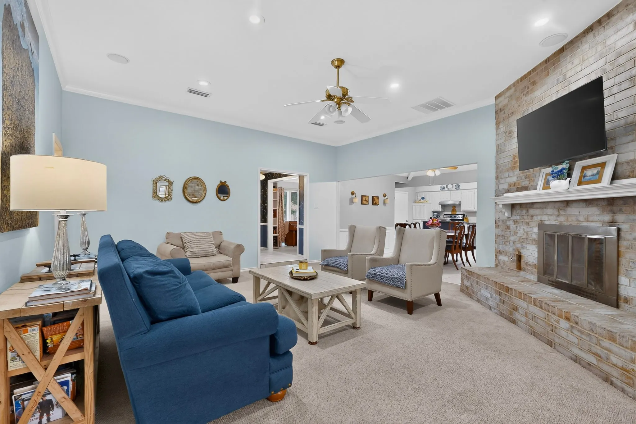 Living area featuring a textured brick fireplace with a mantel, vaulted ceilings, and recessed lighting