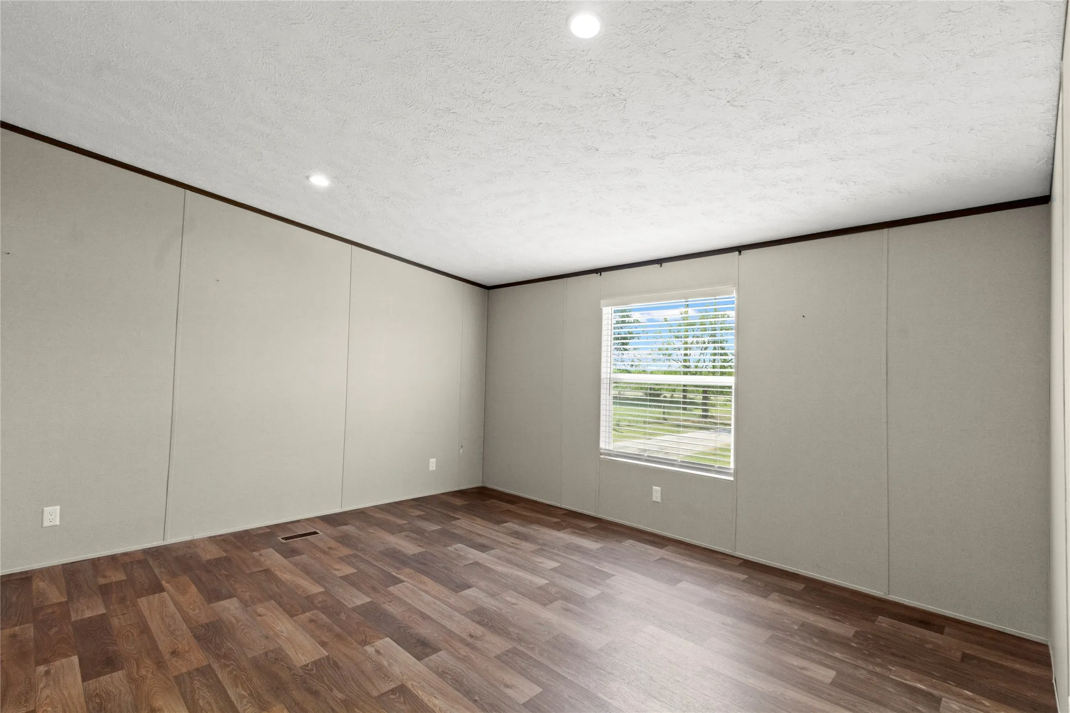Room featuring wood-finish flooring, recessed lighting, and a window with blinds