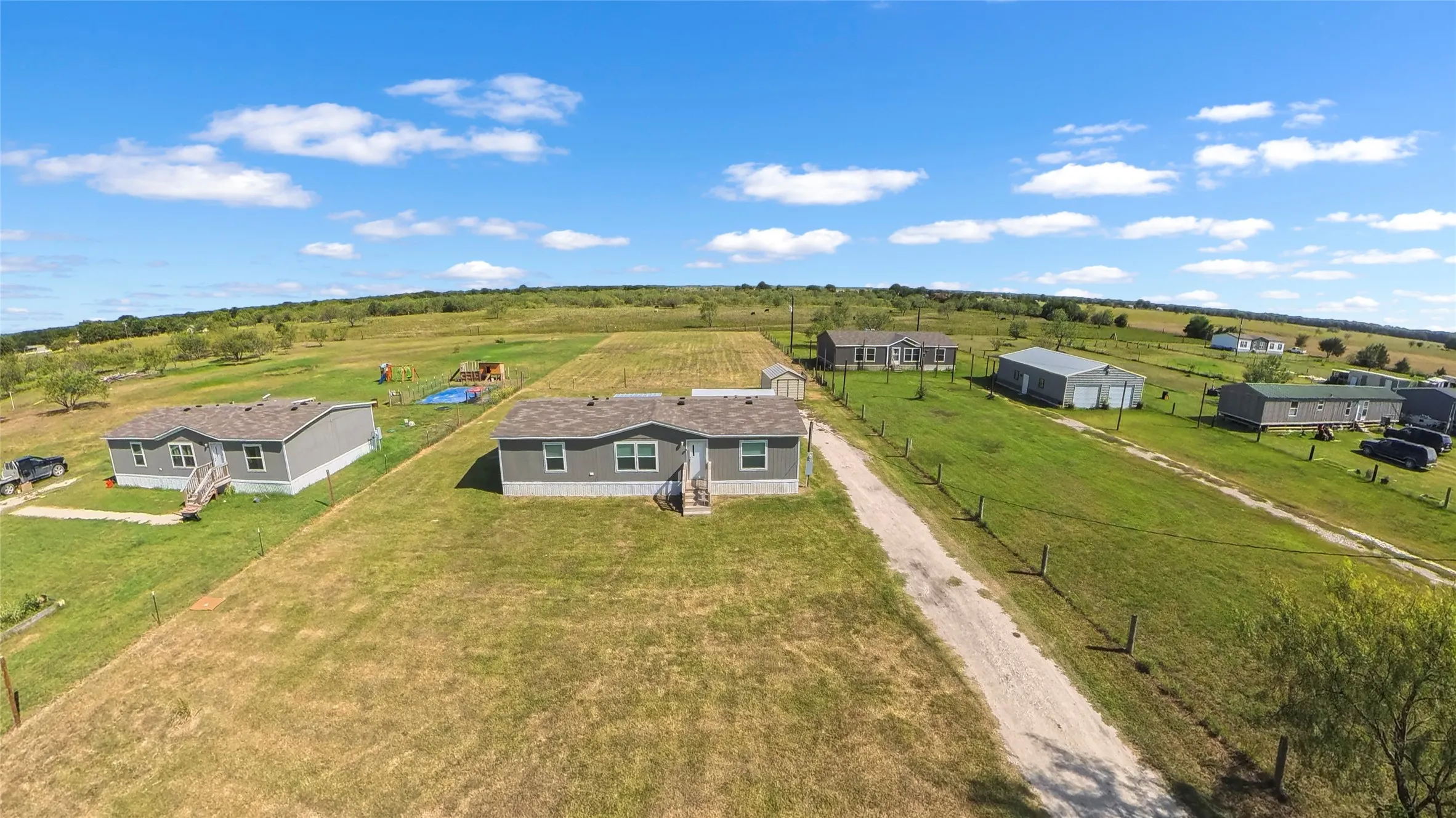 Expansive rural landscape featuring multiple manufactured homes and outbuildings