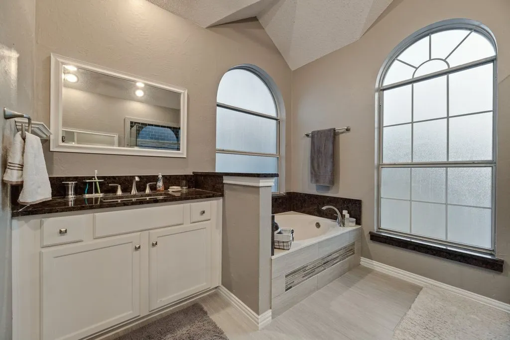 Primary bath with soaking tub and his and her vanities