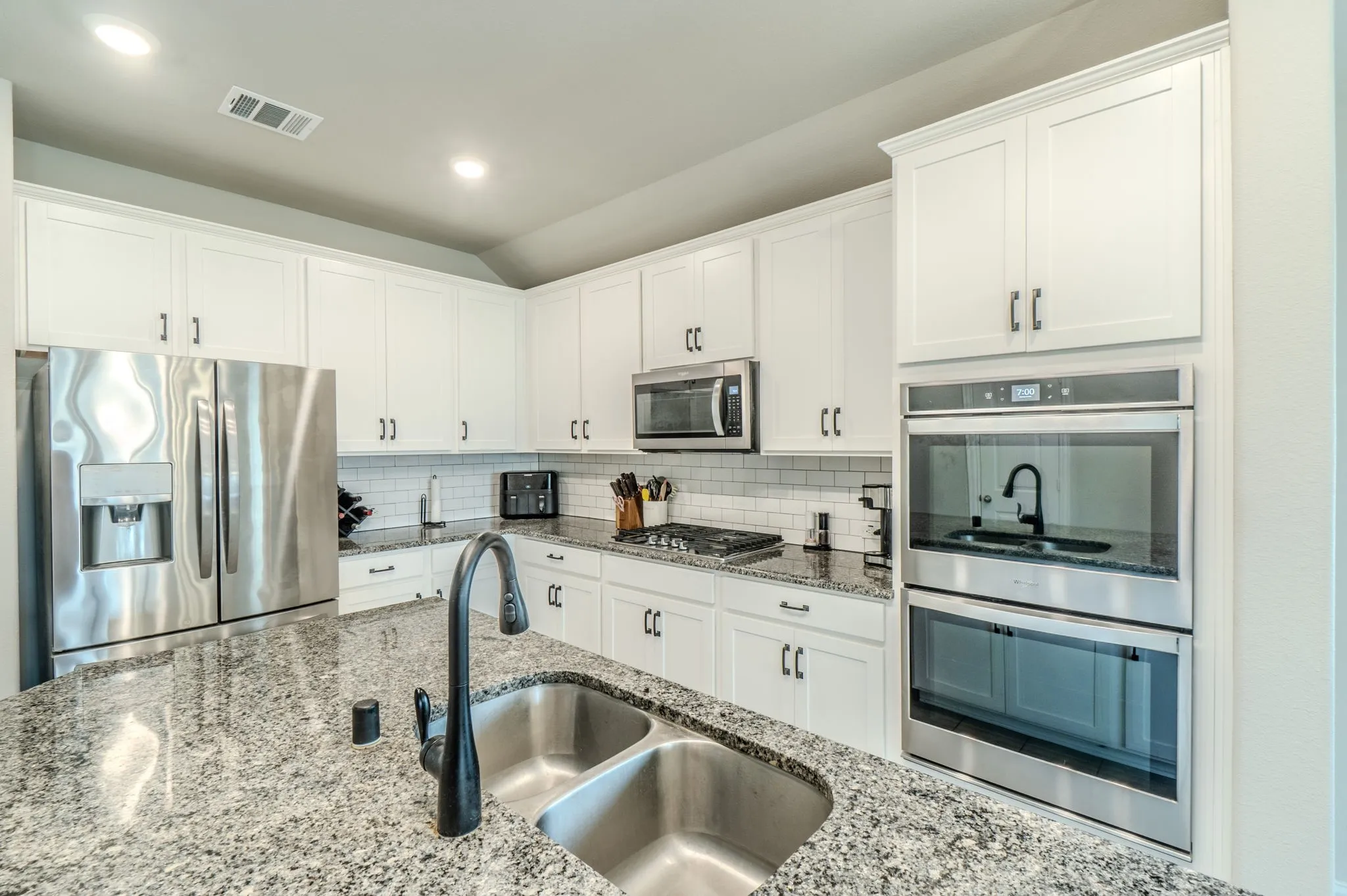 Kitchen island with double basin stainless steel sink and matte black faucet