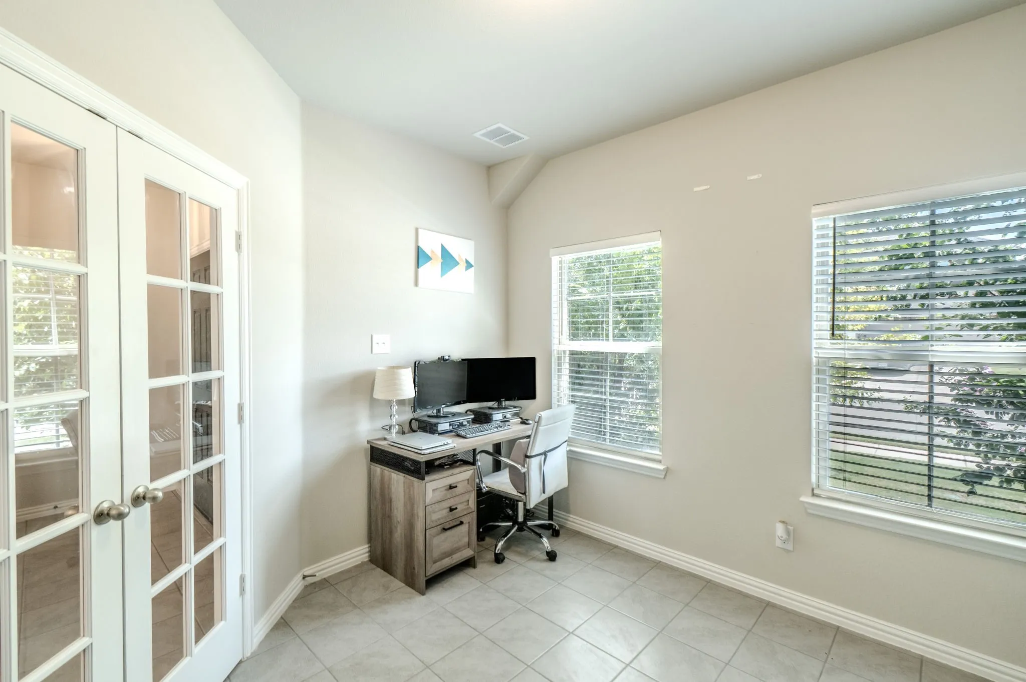 Office room featuring neutral wall tones and light-colored tile flooring. Plenty of Natural light makes this space feel airy and light.
