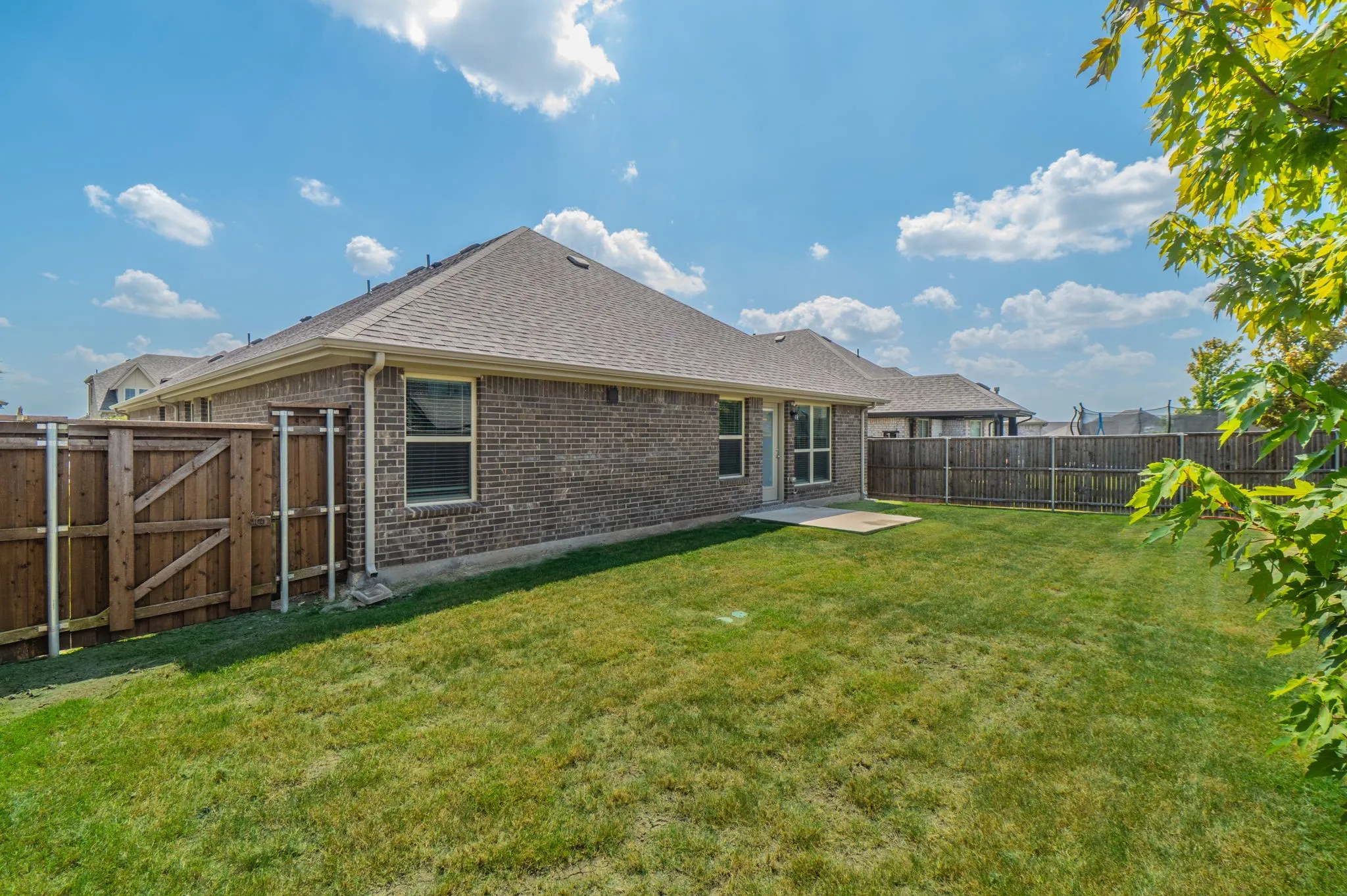 Expansive green lawn with a full privacy fence