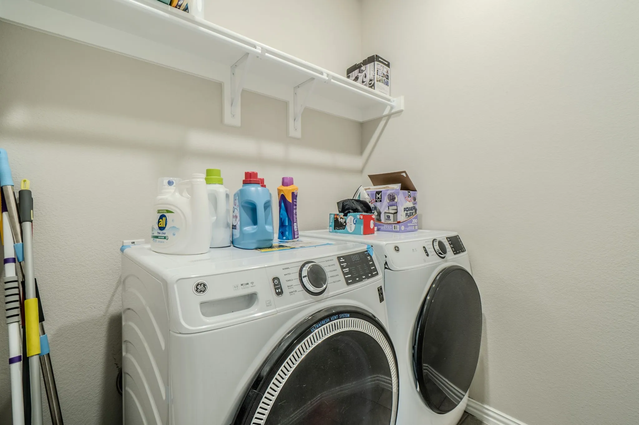 White laundry room with wall-mounted shelving