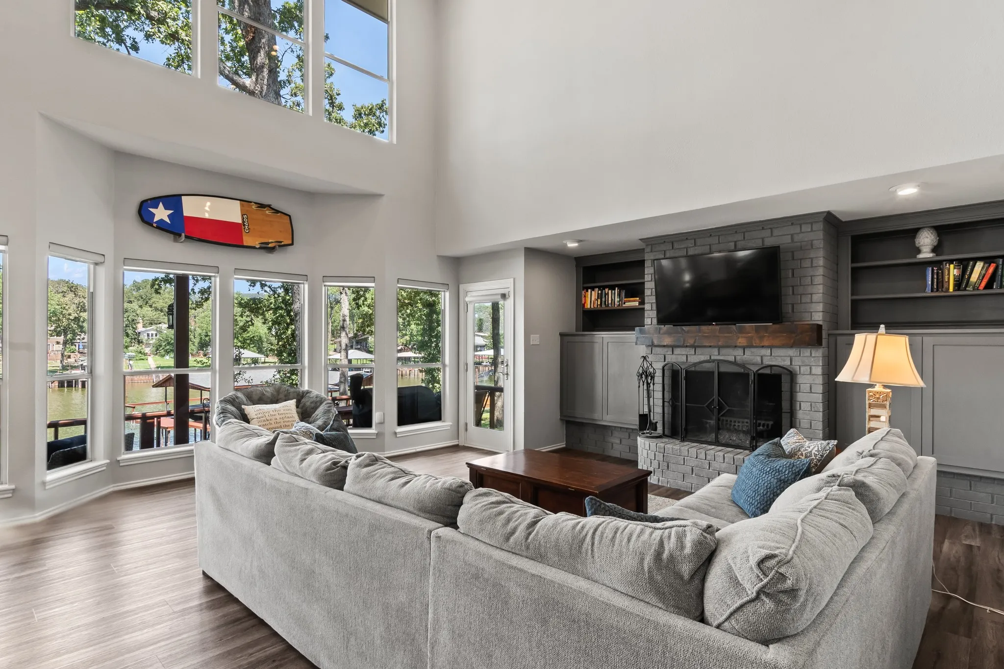 Spacious living room with soaring ceilings.Floor-to-ceiling windows capture stunning lake views.