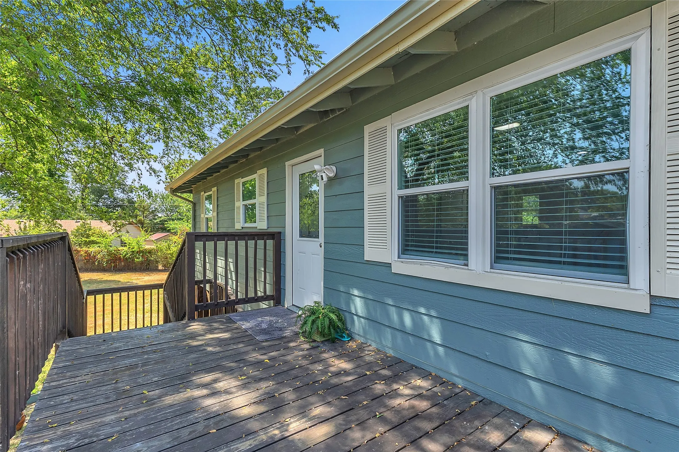 Stairs lead from carport to deck and front door