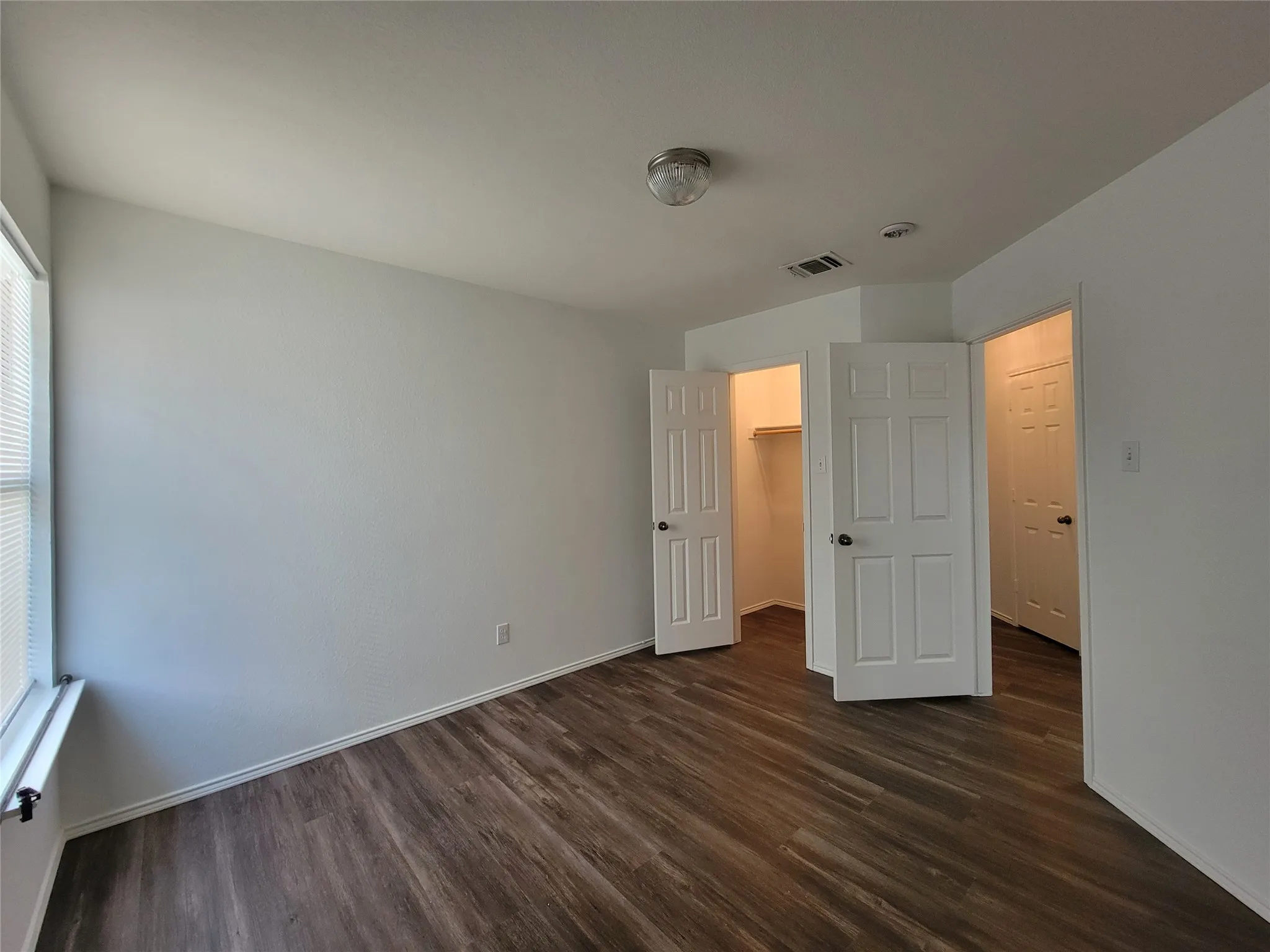 Room featuring wood-finish flooring, white baseboards, and neutral wall paint